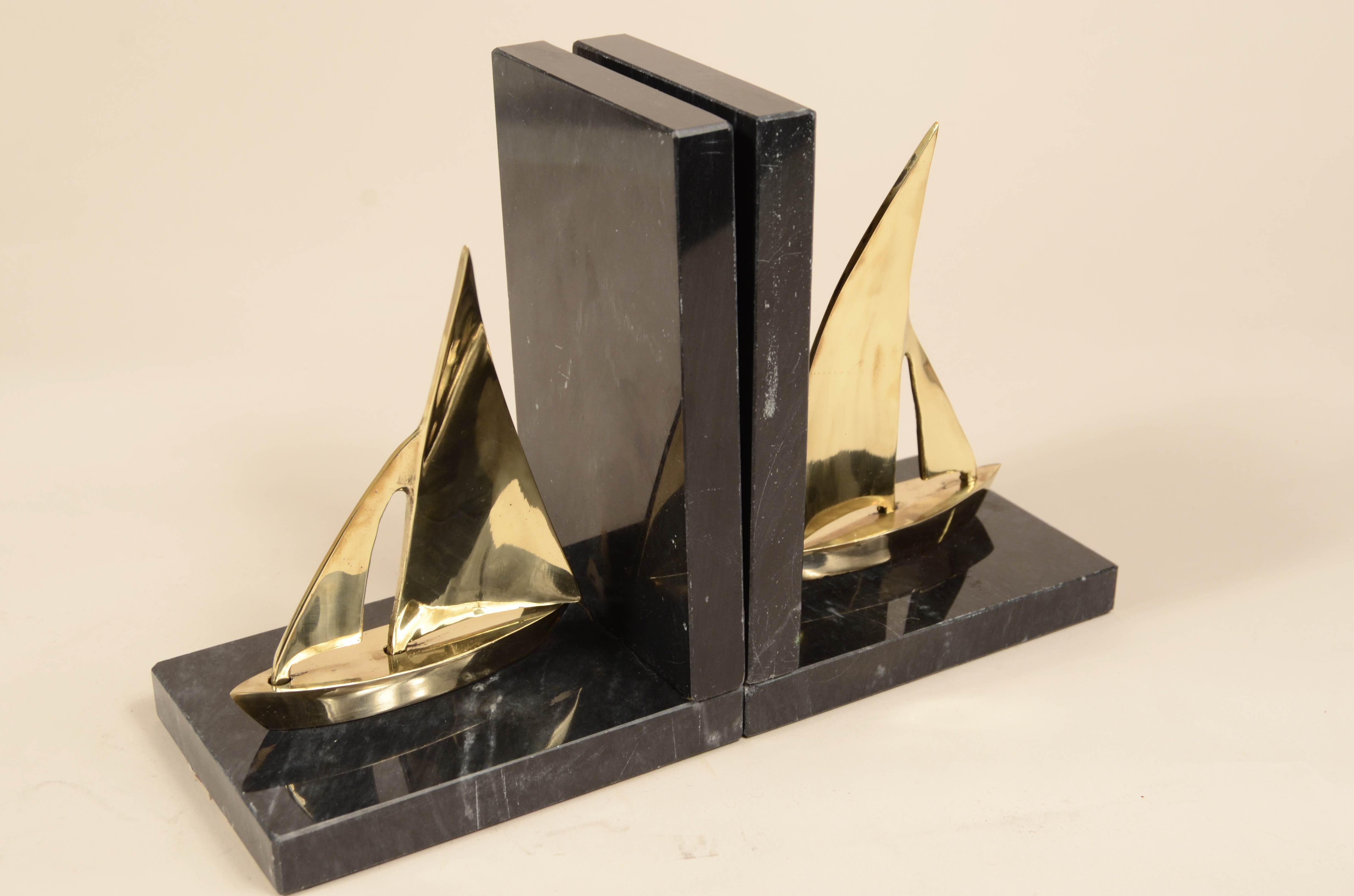 Paire de serre-livres  sur un socle en marbre noir représentant un voilier en laiton. 
Fabrication anglaise des années 1950.
Dimensions 13x9x16.5 cm - pouces 5.1x3.6x6.5.
La dernière photo représente le coffret cadeau.
