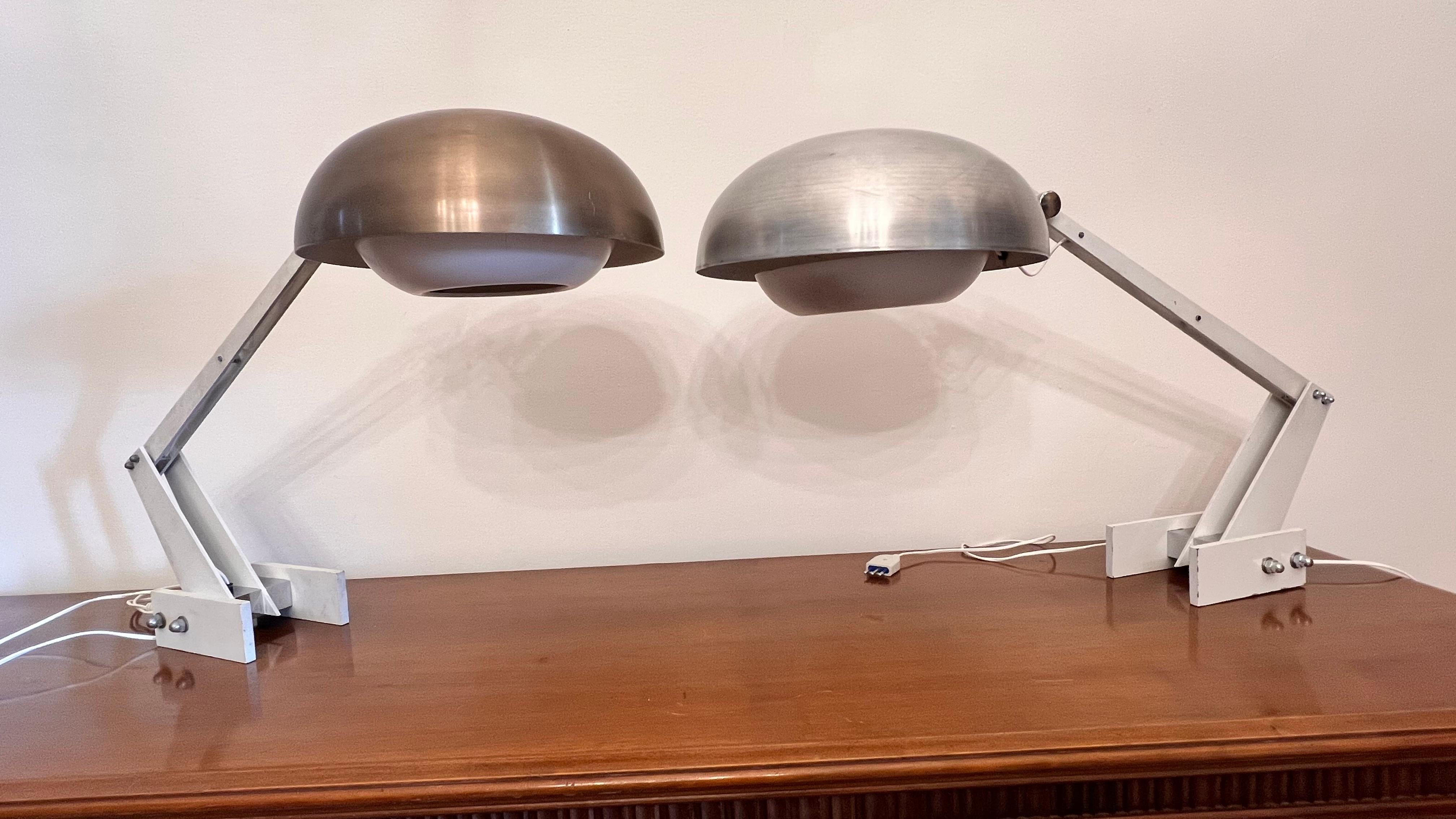 Wunderschönes Paar Tischlampen in verschiedenen Farben, eine mit aluminiumfarbenem Schirm, die andere mit bronzefarbenem Schirm.
Verstellbarer Hut, massiver emaillierter Eisenrahmen
Gebrauchsspuren und Kratzer aufgrund von Gebrauch und Zeit vorhanden