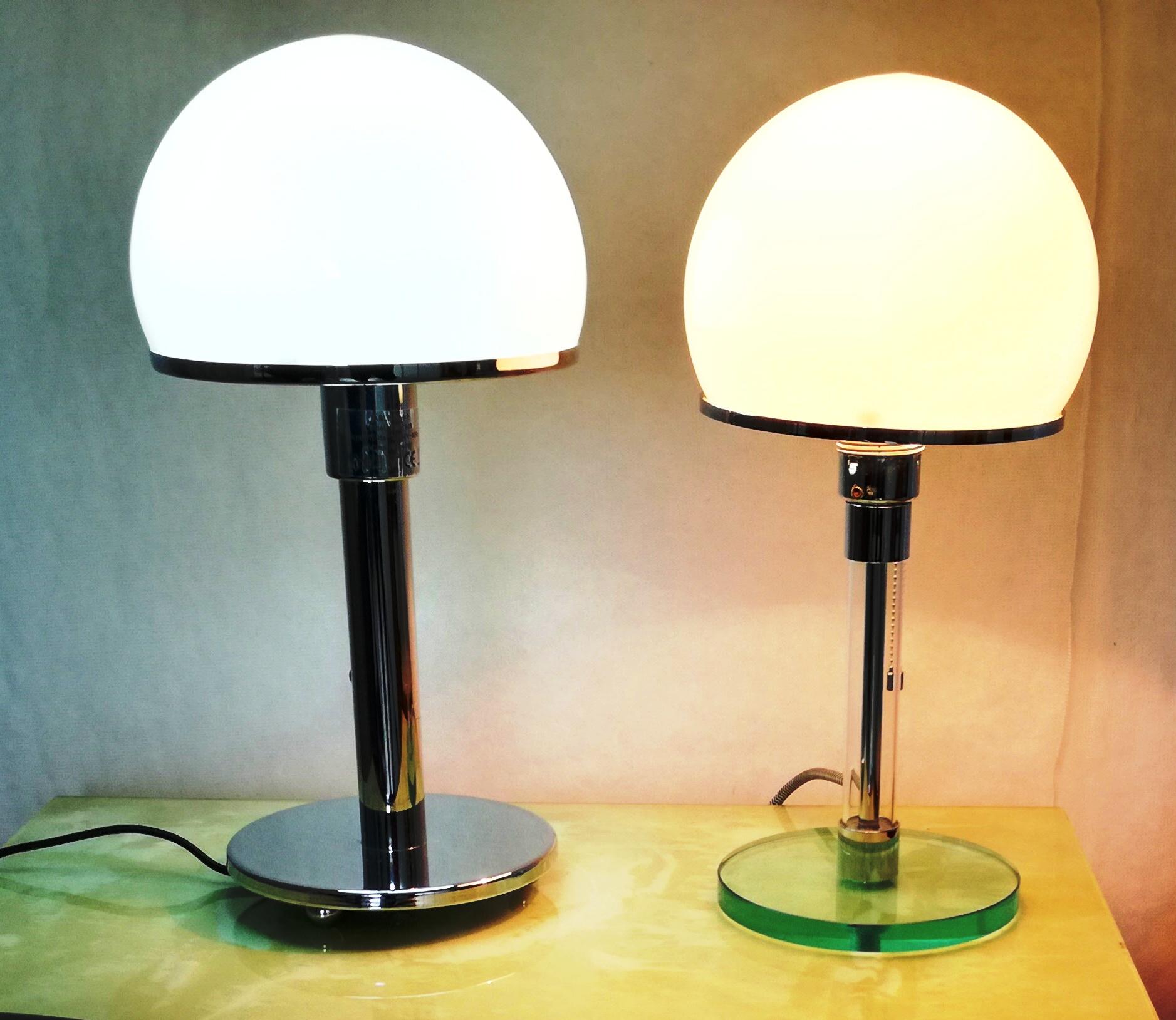 pair of bedside lamps, Bauhaus style. 2 different types. 1990s reissue. one lamp with clear glass stem and base. one lamp with chrome metal stem and base. A classic Bauhaus style by Wilhelm Wagenfeld for Egoluce. e27 bulb socket, pull switch with