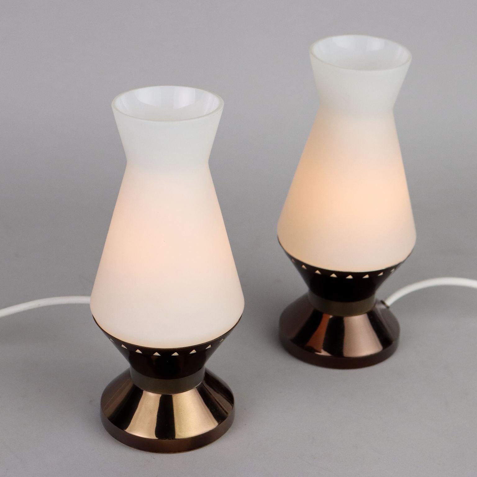 Coppia di lampade da tavolo in ottone e vetro opalino. Riportano il marchio della manifattura. Buone condizioni.