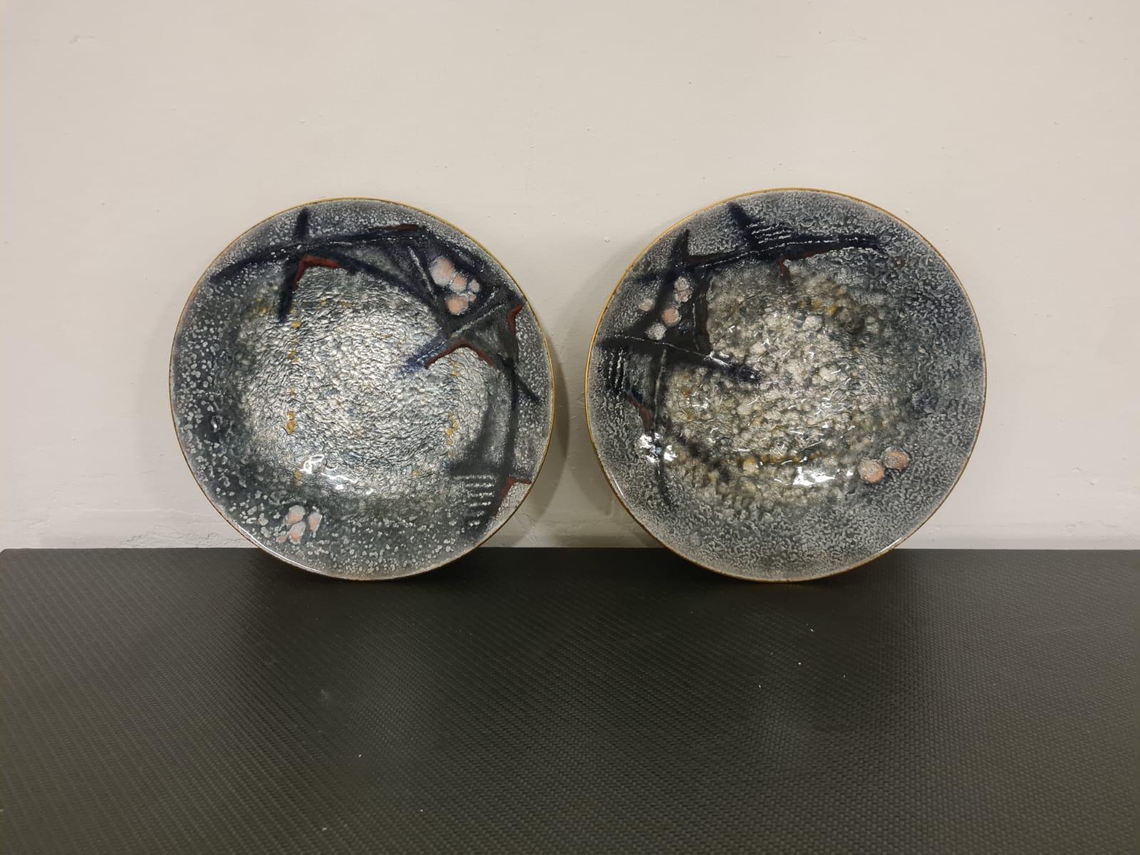 Ein Paar Teller, hergestellt von Studio Del Campo.

Zwei Platten aus Kupfer, die in einem großen Feuer emailliert wurden.

Die aus der Feldstudie hervorgegangenen Objekte sind heute selten und bei Sammlern sehr begehrt.

Die beiden Platten sind in