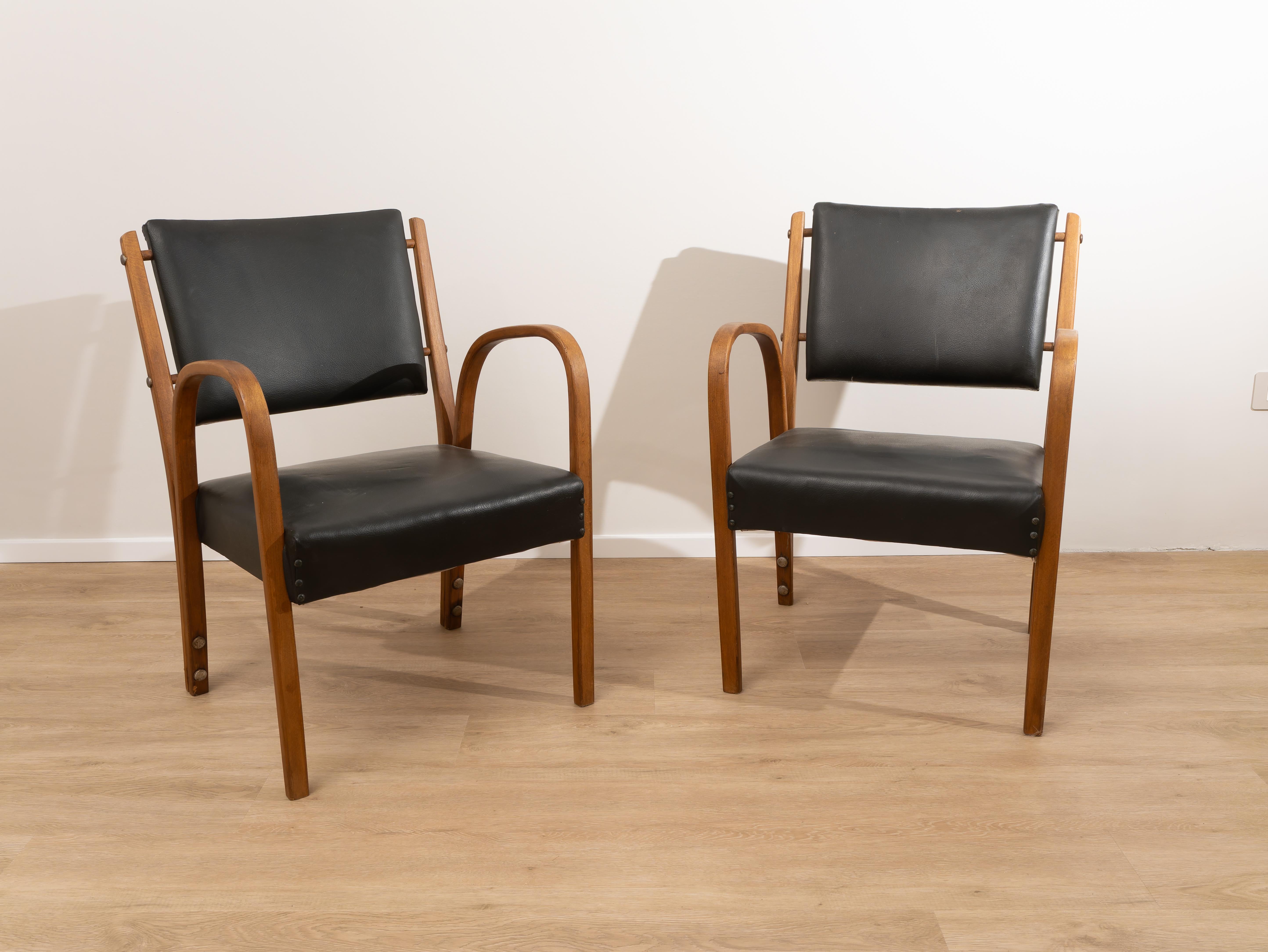 Paire de fauteuils de Luigi Ricci, fabriqués en Italie, années 1950. 
Paire de fauteuils fabriqués dans les années 1950 par Luigi Ricci. Les boiseries et la sellerie en skaï noir sont en bon état. Avec leur élégance, les fauteuils ont des lignes
