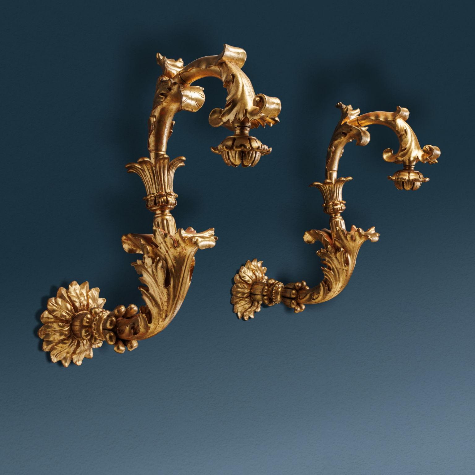 Paar Laternenhalter mit Eisenrahmen und geschnitztem und vergoldetem Holzkörper. Die Arme sind S-förmig und das Holz ist mit den charakteristischen Blumen- und Blattmotiven geschnitzt, die sich kräuseln, ein Ausdruck des barocken Geschmacks. Die