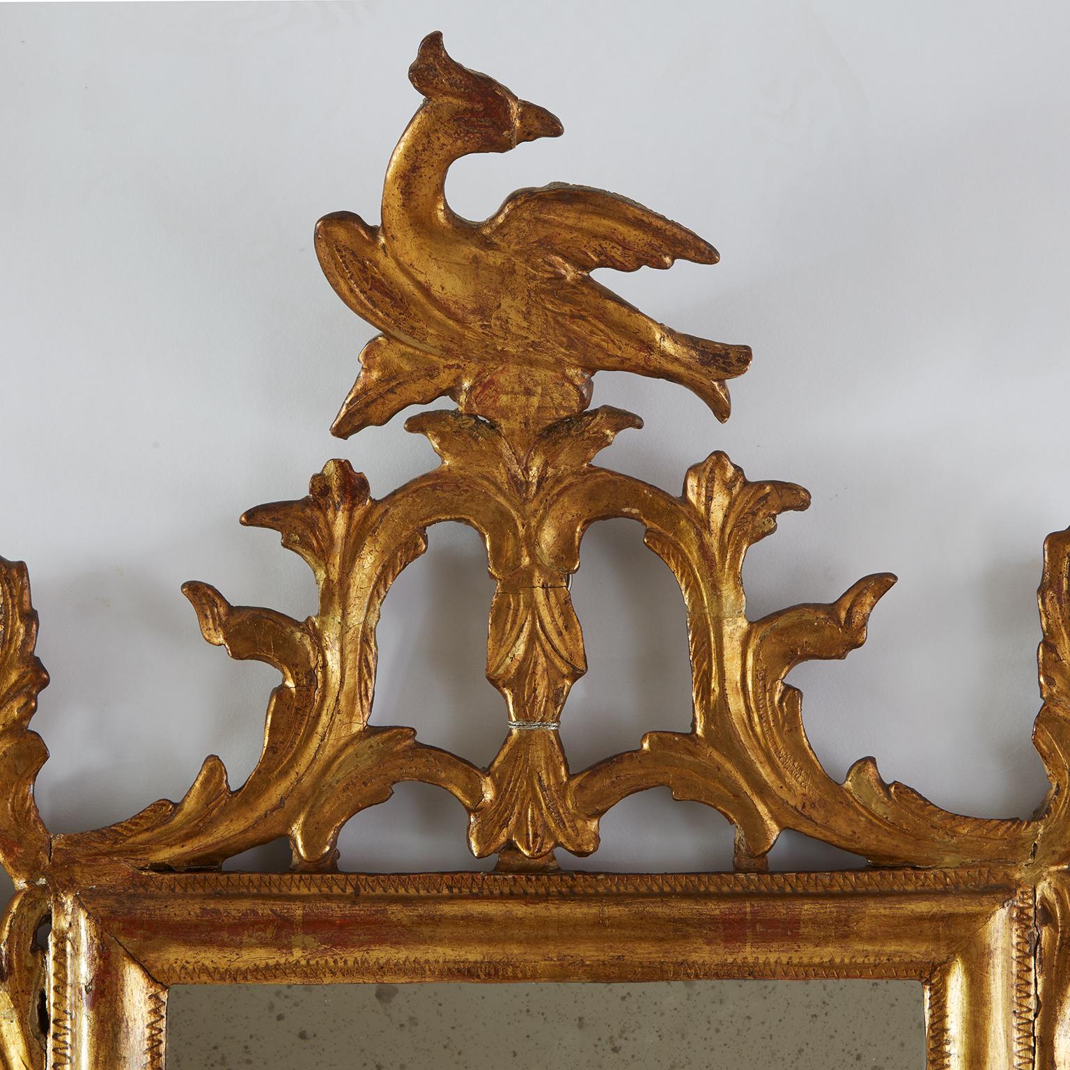 Coppia Di Specchi Dorati italiani di gusto Luigi XVI dell'inizio 1800 formati da una cornice di forma rettangolare con una sagoma semplice a mezzo toro decorata nei bordi da una zigrinatura. Nella cimasa vi sono decorazioni intagliate di racemi