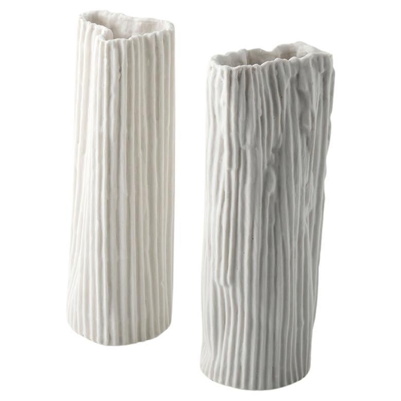Elegant pair of paperclay porcelain vases from the collection  Landscape under the moon, conceived by designer-artist Nino Basso. 
The vase set  has basic design and texture in white color with vertical stripes in relief;  the vessels are enriched