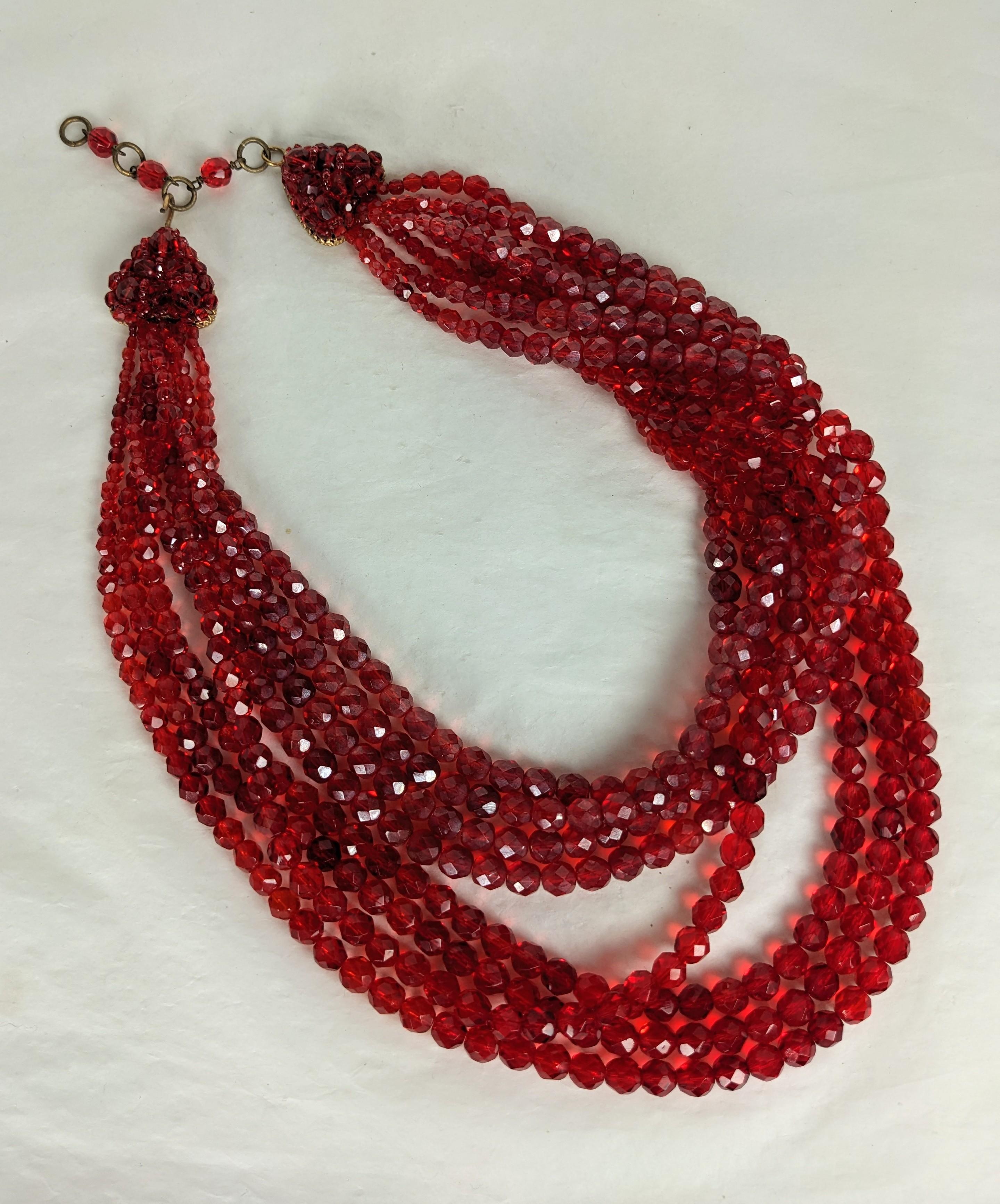 Collana di cristalli di rubino drappeggiati di Coppola e Toppo degli anni '50. 8 fili di cristalli di rubino sfaccettati sono intrecciati e manipolati con un motivo drappeggiato su un lato per sembrare disinvoltamente attorcigliati. Chiusura con