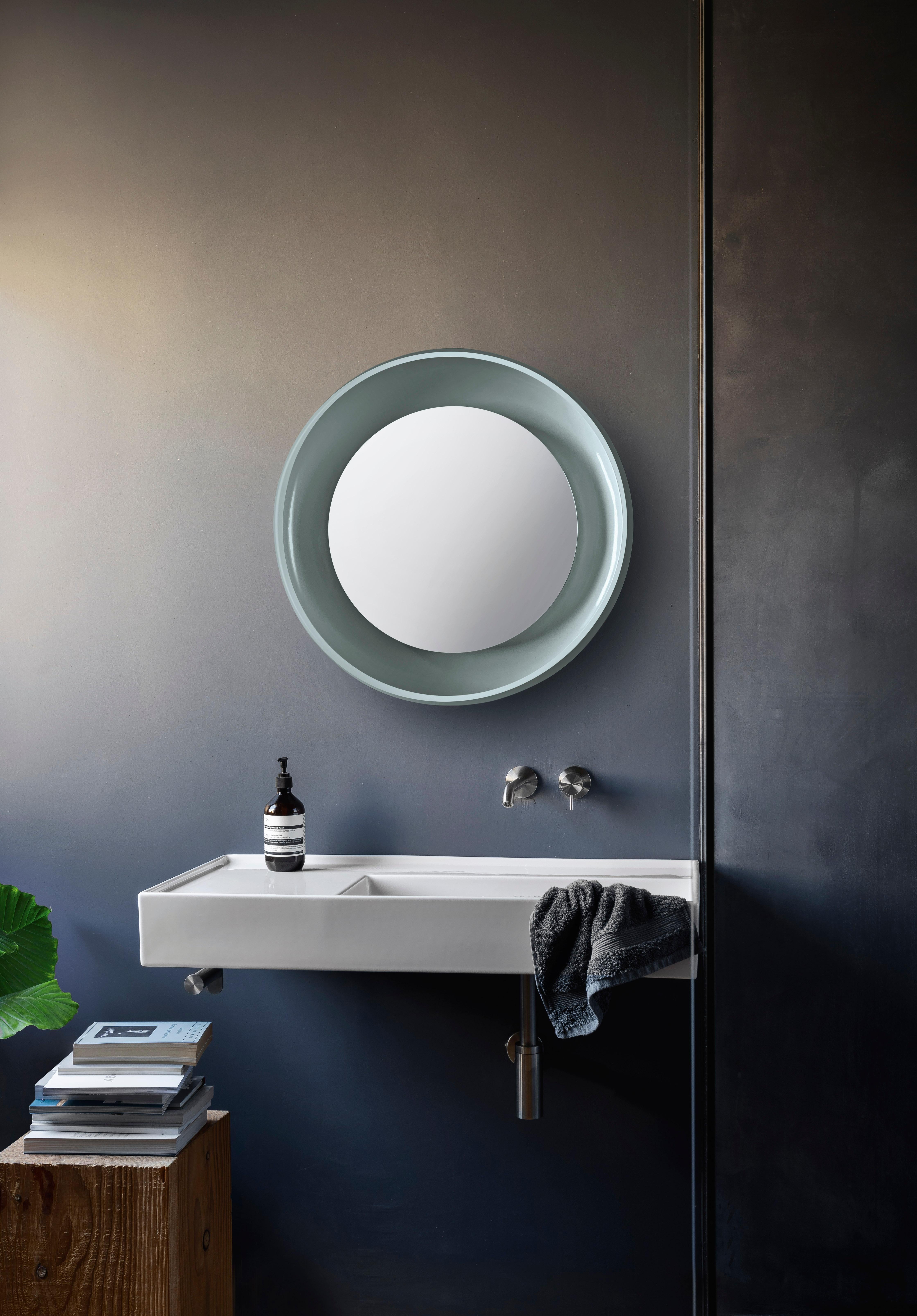 Coque has a taste for dynamic, rich contrasts. The mirror is protected by a ceramic shell, which embraces two opposing finishes: glossy and matt. The inner surface is enamelled and shiny, while the outer skin is textured. The mirror is transformed