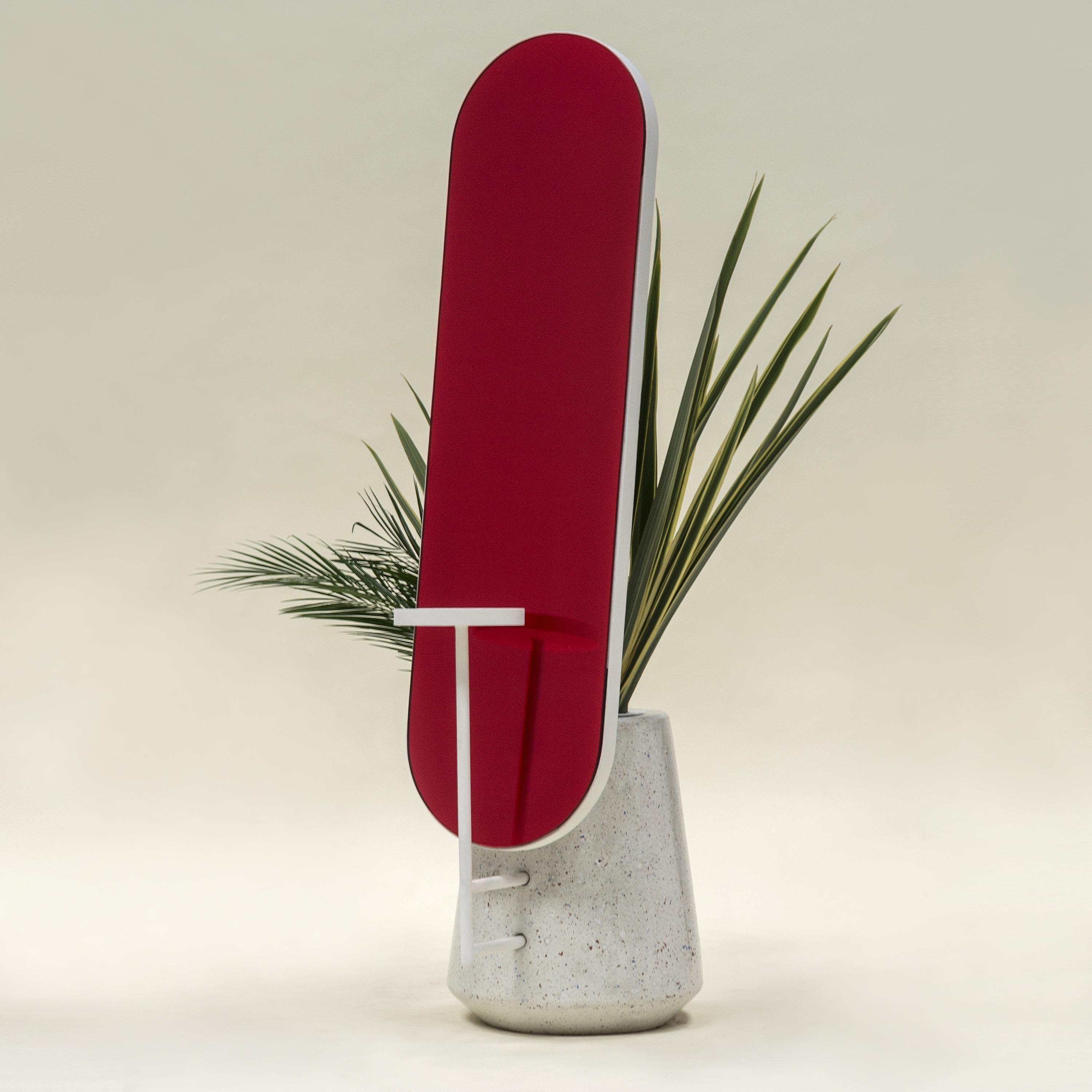 Surfaces that reflect an image, a painting that is constantly changing. With elegant and feminine forms Coqueta enhances any space.
Coqueta, a concrete base that can be used as a plant-pot support a red mirror and a white tray, an object that is