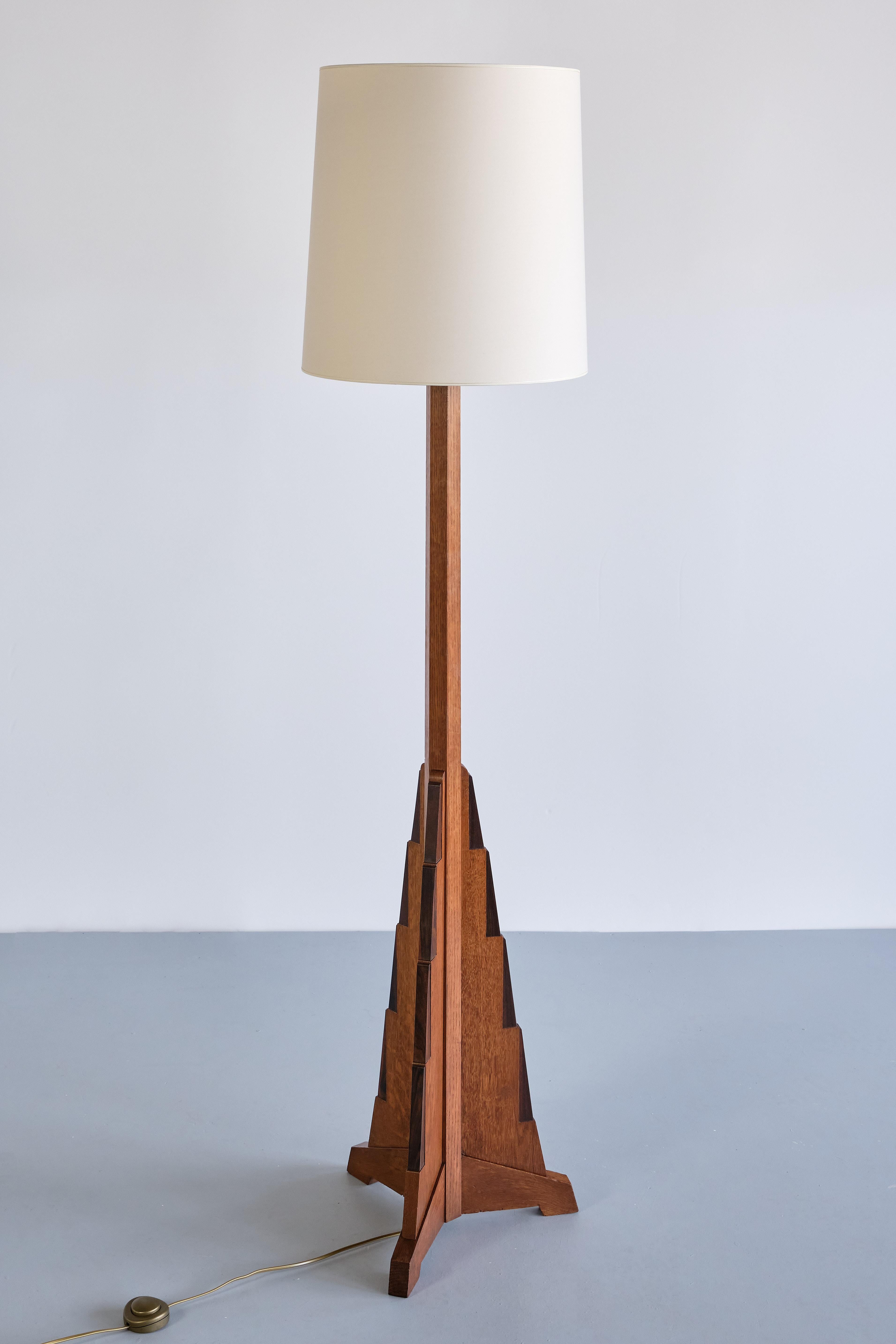 This rare floor lamp was designed by the Dutch designer and architect Cor Alons in the early 1930s.
The design is defined by the geometric, triangular shape of the base which was executed in solid oak wood. The tiered base on three slightly raised