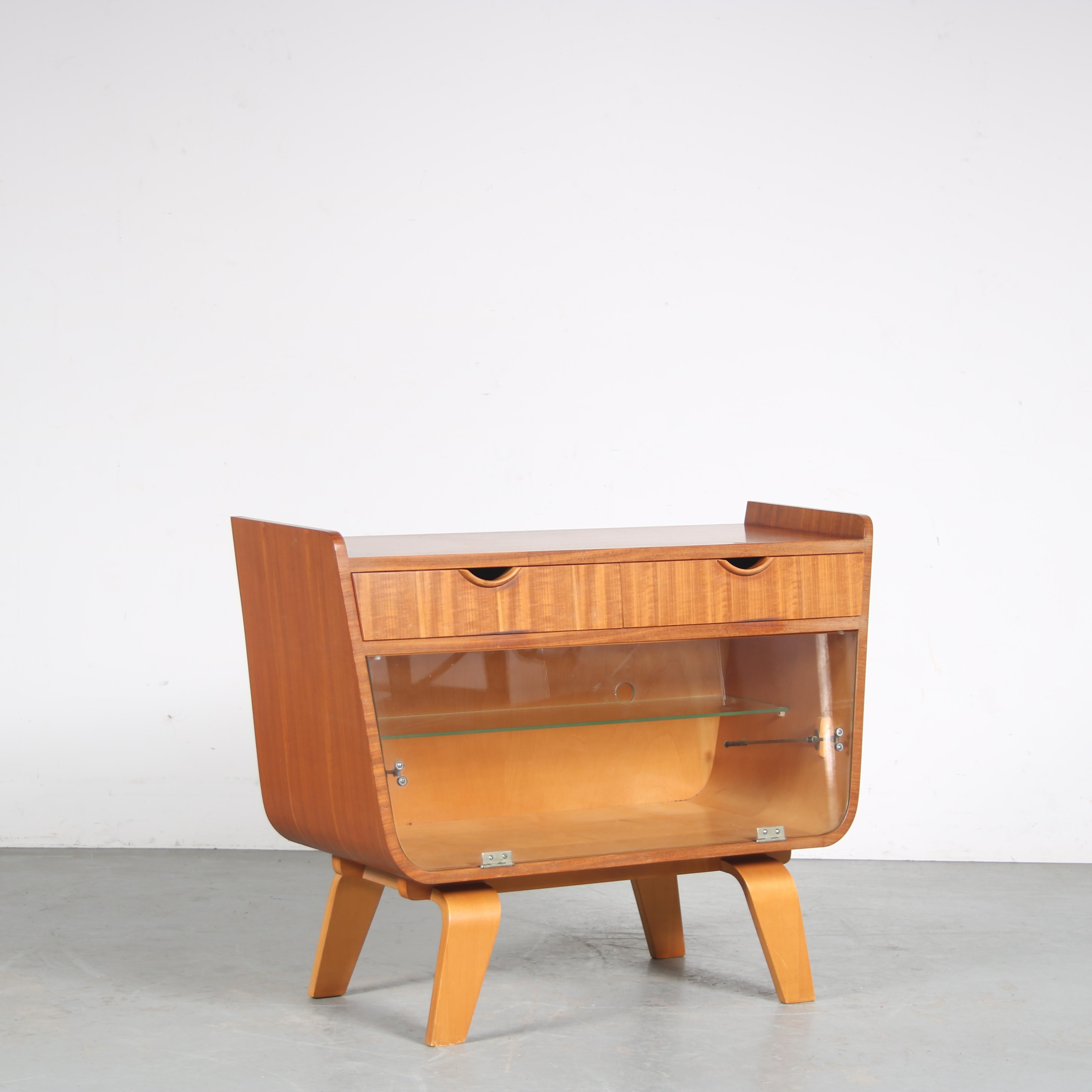A lovely small bar cabinet designed by Cor Alons and manufactured by De Boer Gouda in the Netherlands around 1950.

It is made of high quality birch wood and plywood with a glass drop down door. The rounded finish and curved legs are recognizable