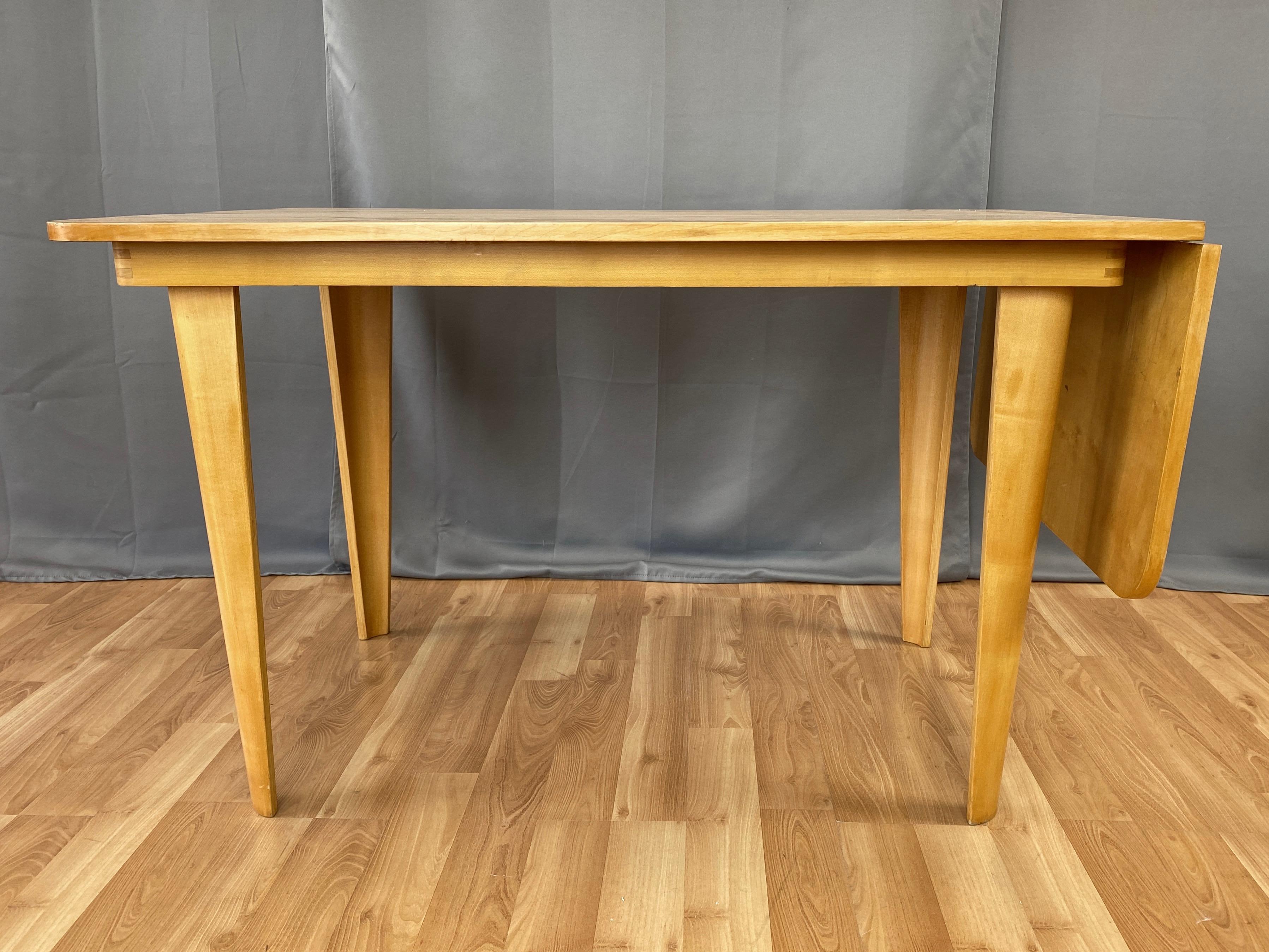 A circa 1949 birchwood drop-leaf dining table by important Dutch designer Cornelius Louis “Cor” Alons for Gouda den Boer.

Clean mid-century modern lines distinguished by skillfully executed and generously sized concave bentwood tapered legs.