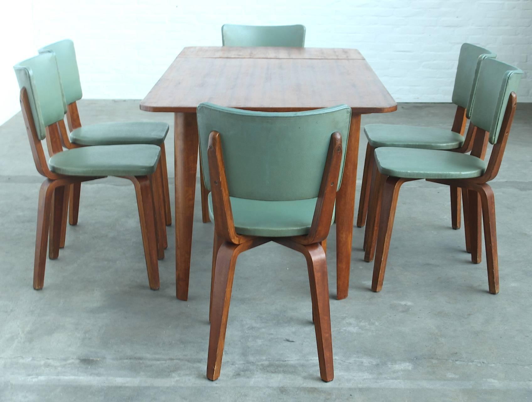 Very rare dining room set of an extendable dining table with its six matching chairs upholstered in wonderful sea green coloured leatherette, which is the original upholstery. The green upholstery combined with the tanned plywood of the chairs and
