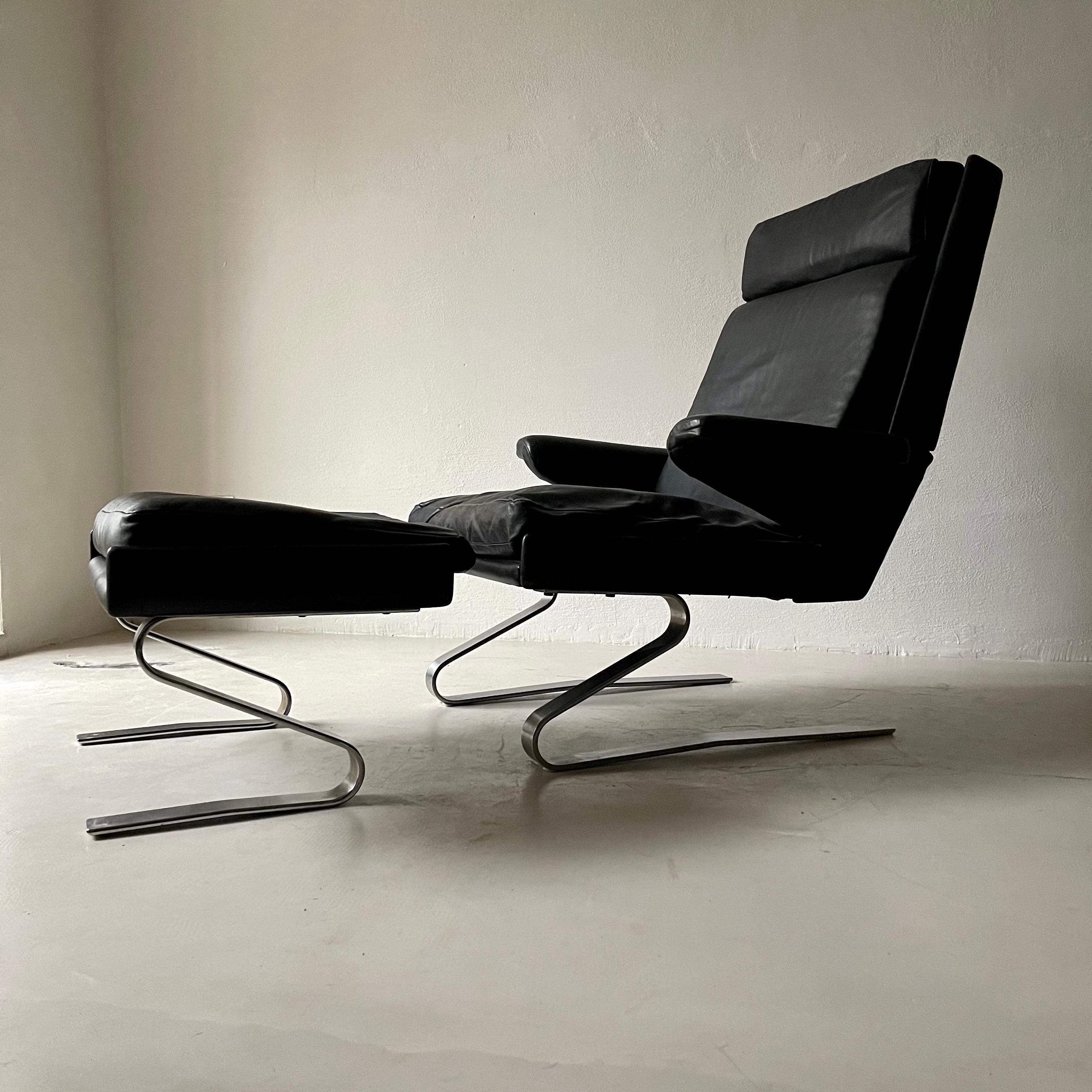 COR swing lounge chair with ottoman. Designed 1972 by Reinhold Adolf and Hans-Jürgen Schröpfer. Upholstered in original patinated black leather. Comfortable and minimalistic.