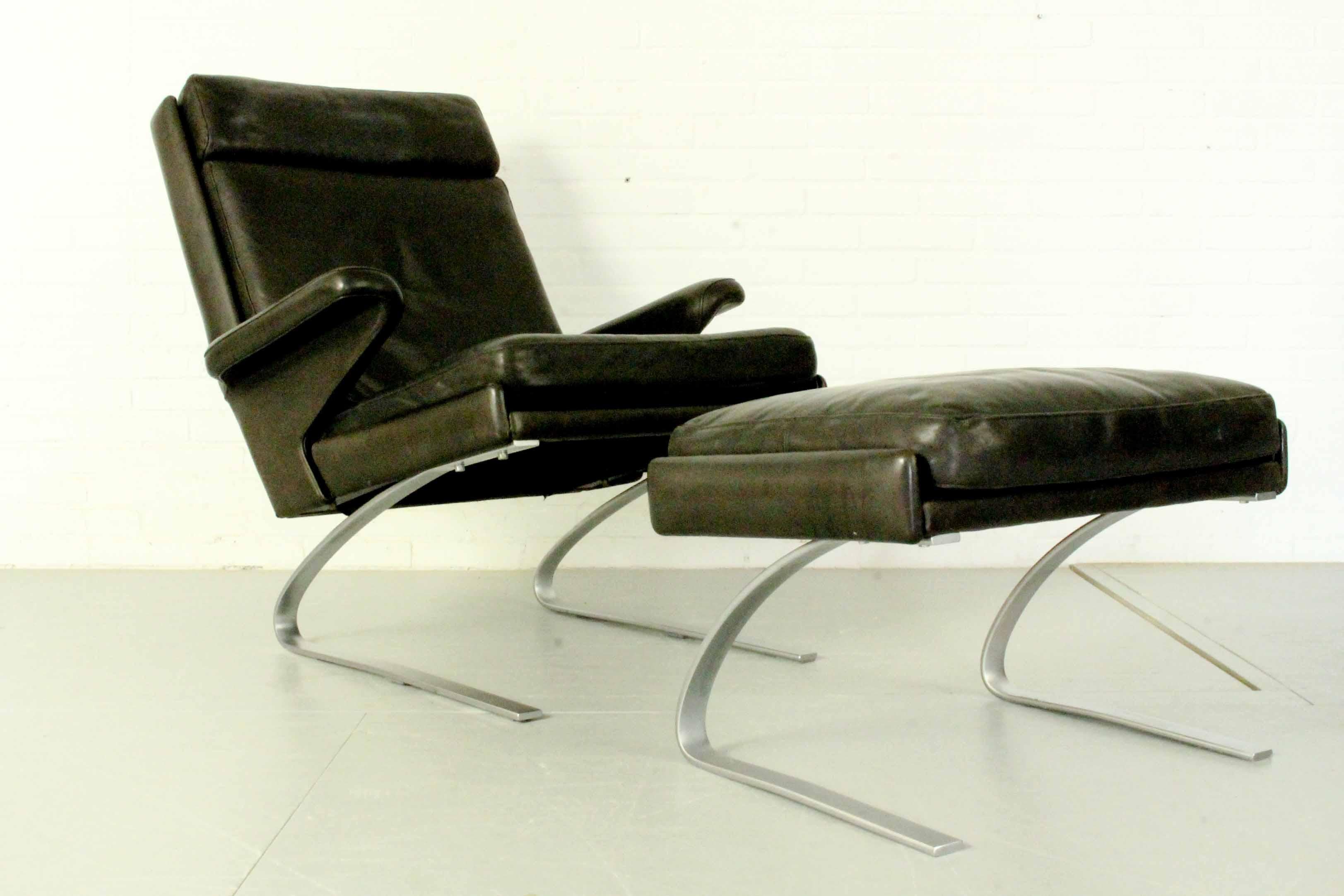 Swing lounge chair with ottoman designed by Reinhold Adolf and Hans-Jürgen Schröpfer for COR Germany. This set is fully original with black leather patinated by age and use. Two sets of lounge chair + ottoman available. 

Price per set of 1 lounge