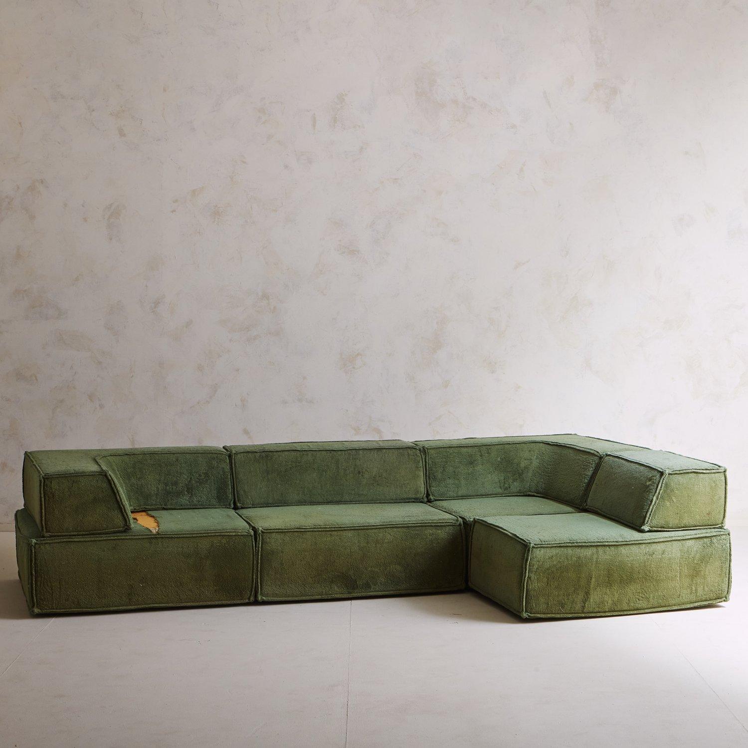 A Cor Trio modular sofa designed by Team Form AG in 1972. This elegant sofa sits directly on the ground and has four sections with removable backrests. It retains its original green upholstery and has beautiful double pinched welt. Sourced in