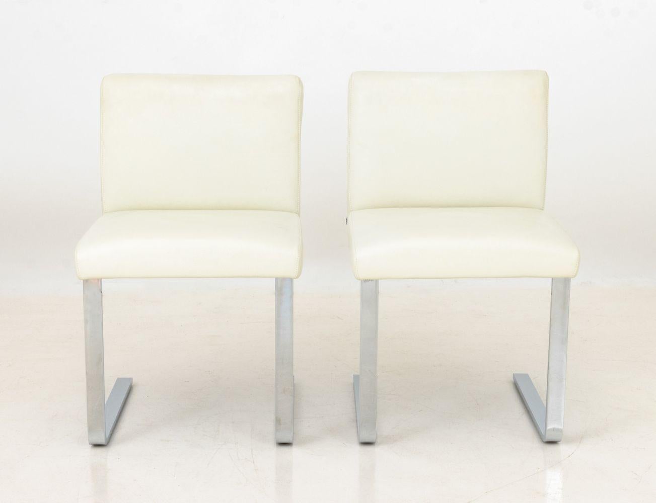 Coppia di sedie da pranzo CORS rivestite in pelle bianca e cromate, etichette sul retro e sul lato inferiore. 31,5