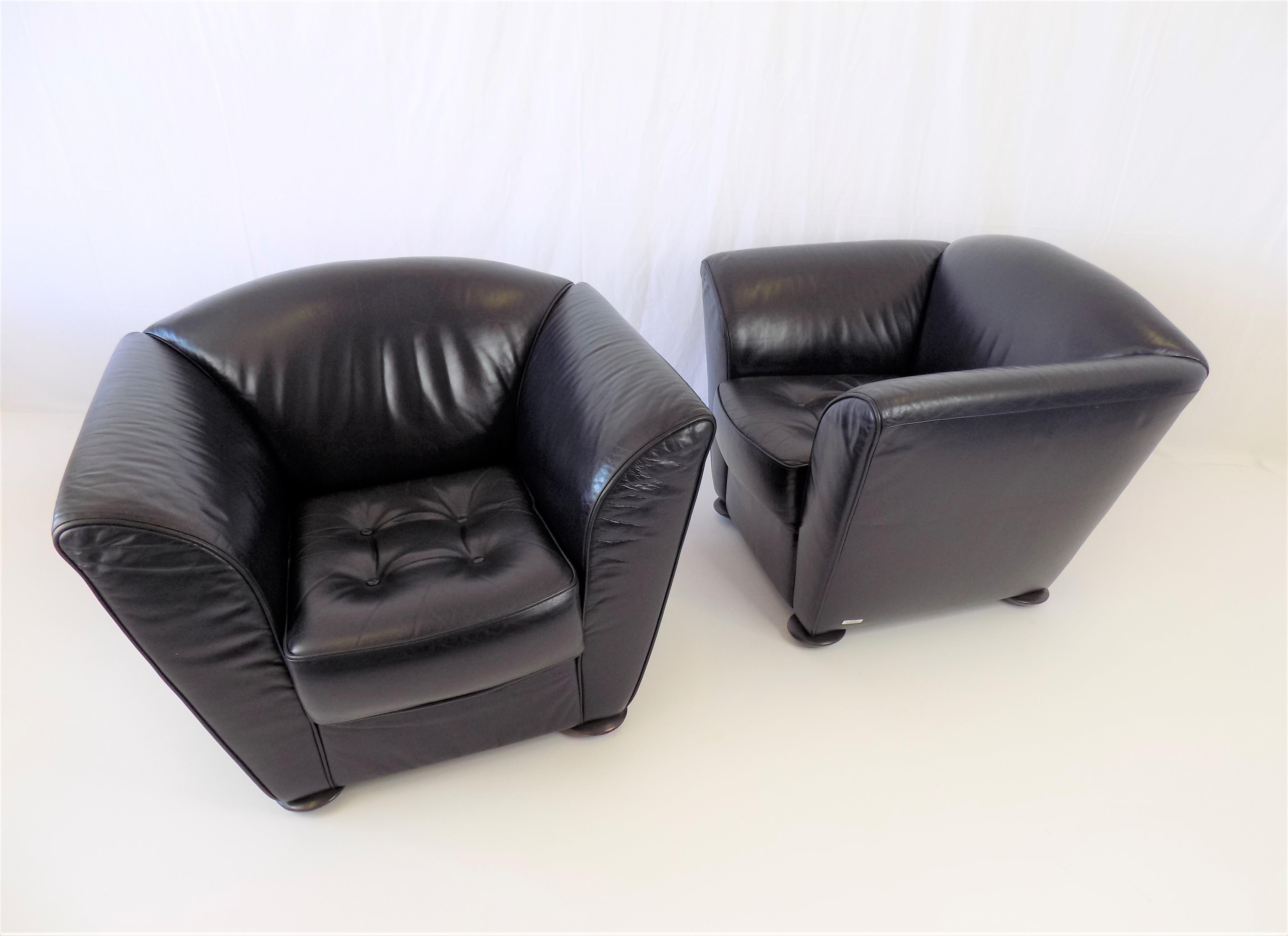 This set of 2 Zelda leather armchairs in elegant dark blue leather is in very good condition. The leather shows minimal signs of wear, the seating comfort is impeccable, thanks in part to the thick seat cushion with Chesterfield buttons, . These two