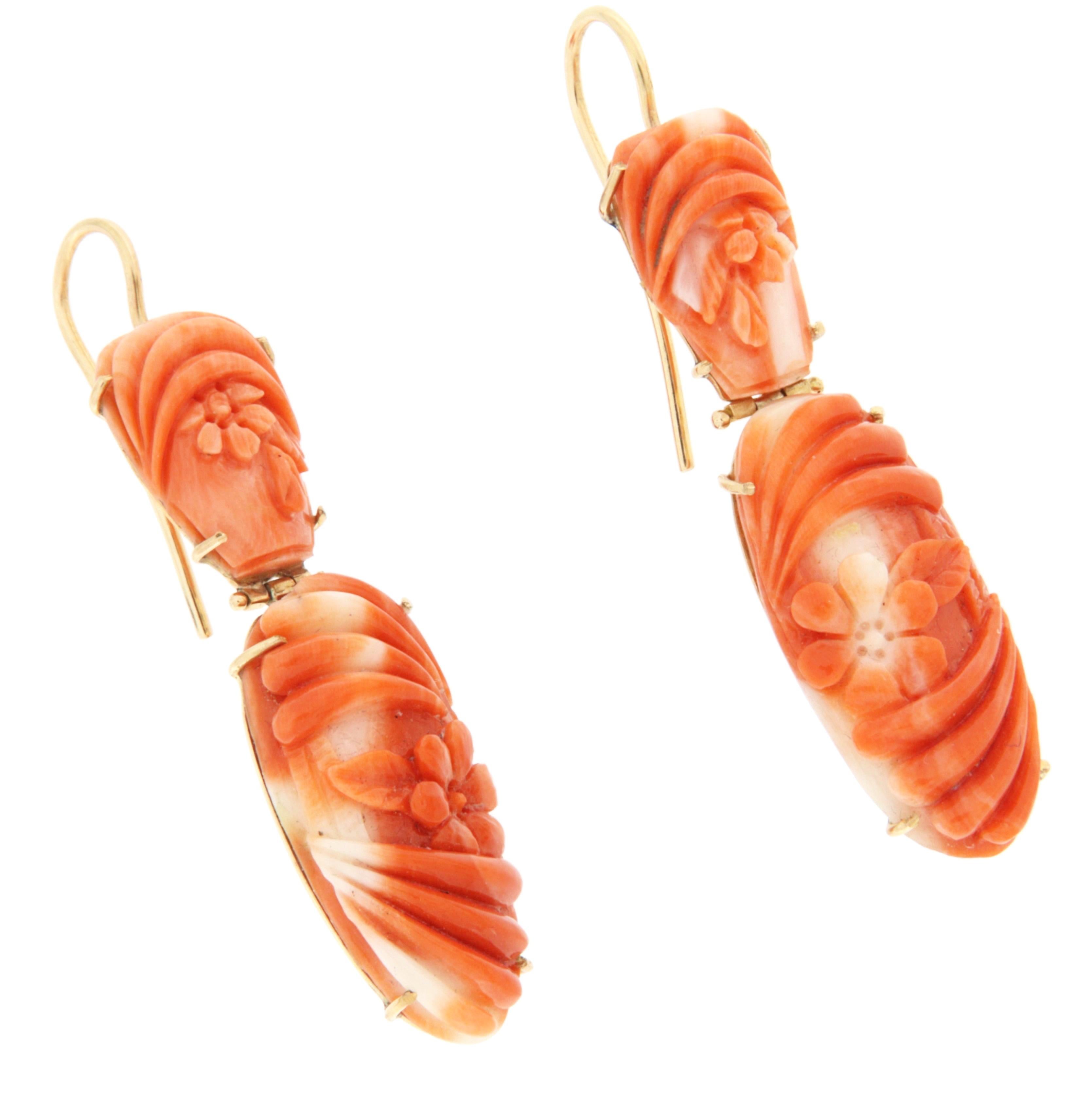 Ces élégantes boucles d'oreilles rétro sont réalisées en or jaune 14k (585/1000) et serties de corail finement sculpté à la main, pour un poids total de 7,60 grammes. Le corail présente une riche teinte rouge orangé naturelle avec de délicates