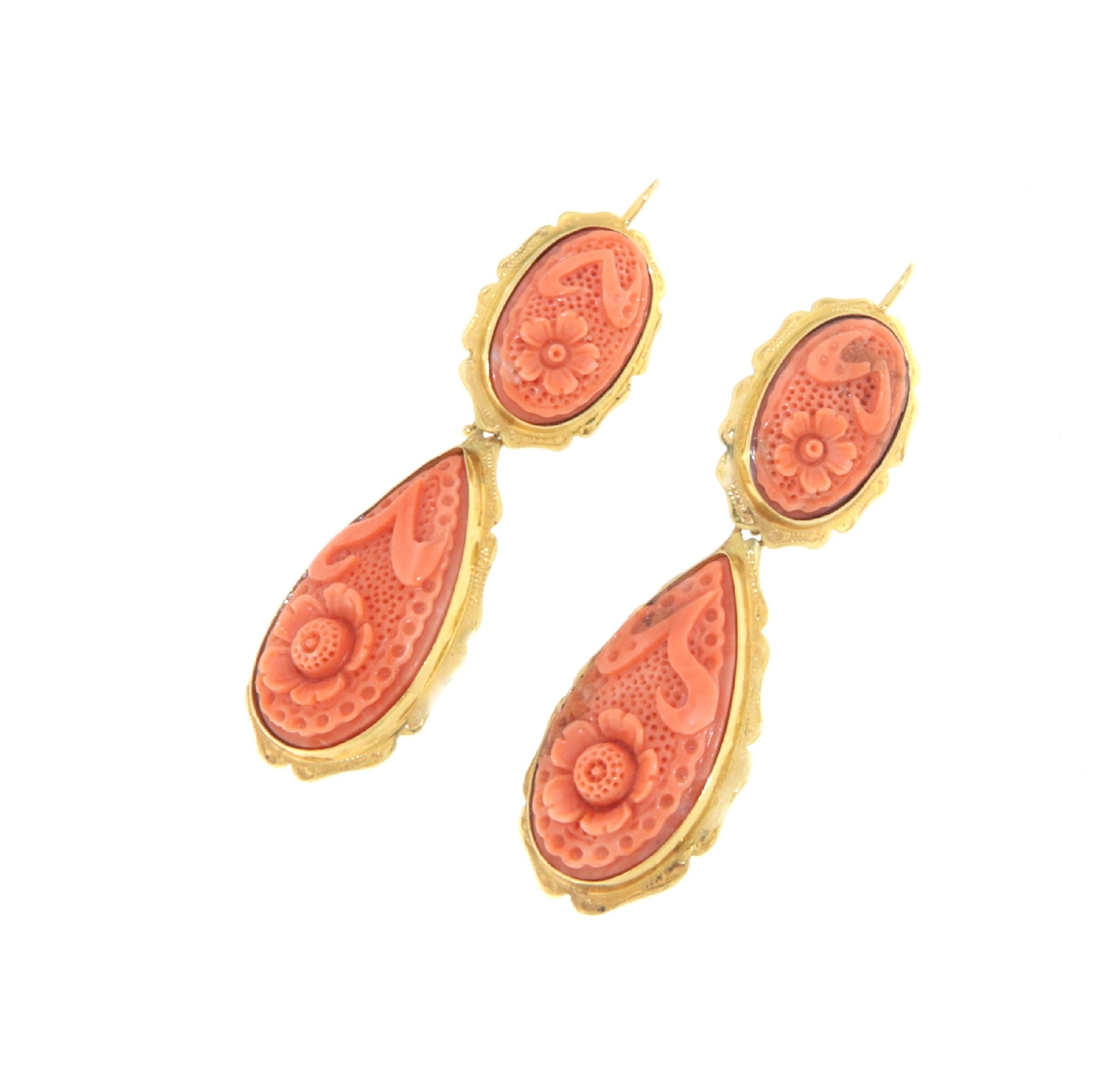 Diese raffinierten Ohrringe sind aus 14-karätigem Gelbgold gefertigt und mit eleganten Korallenschnitzereien versehen, die für handwerkliches Können und klassischen Charme stehen. Jeder Ohrring zeigt detaillierte, in die Koralle geschnitzte
