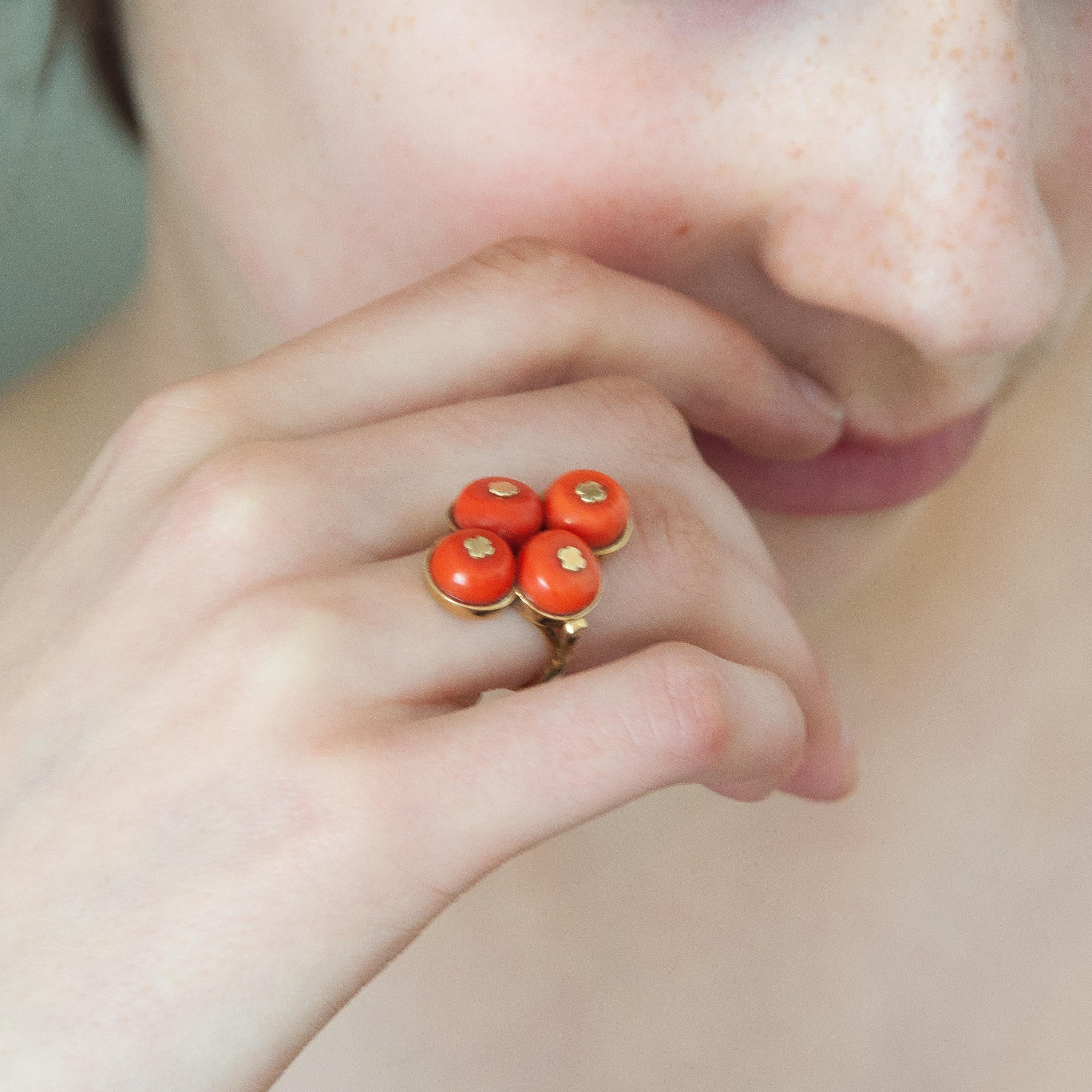 A vintage jewelry set of natural coral featuring a ring and stud earrings. This set is created in 14 karat gold with beautifully natural coral bead stones. The corals have a gold cap on top to hold the bead at it's place. The corals are clustered