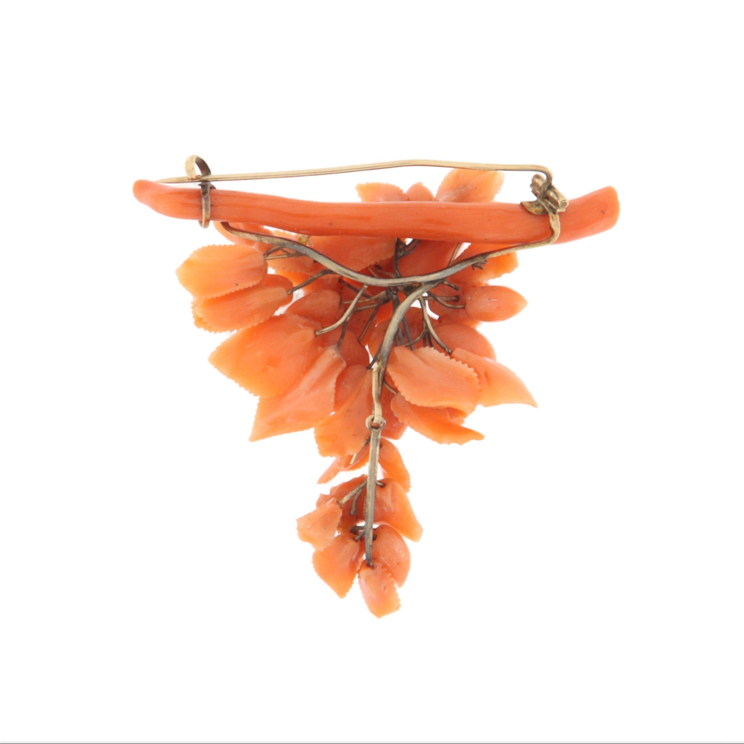 This exquisite brooch is a true masterpiece of fine craftsmanship, made of 9-karat yellow gold and adorned with a delicate floral motif entirely hand-carved from natural coral. Every detail of the bouquet of roses is sculpted with remarkable
