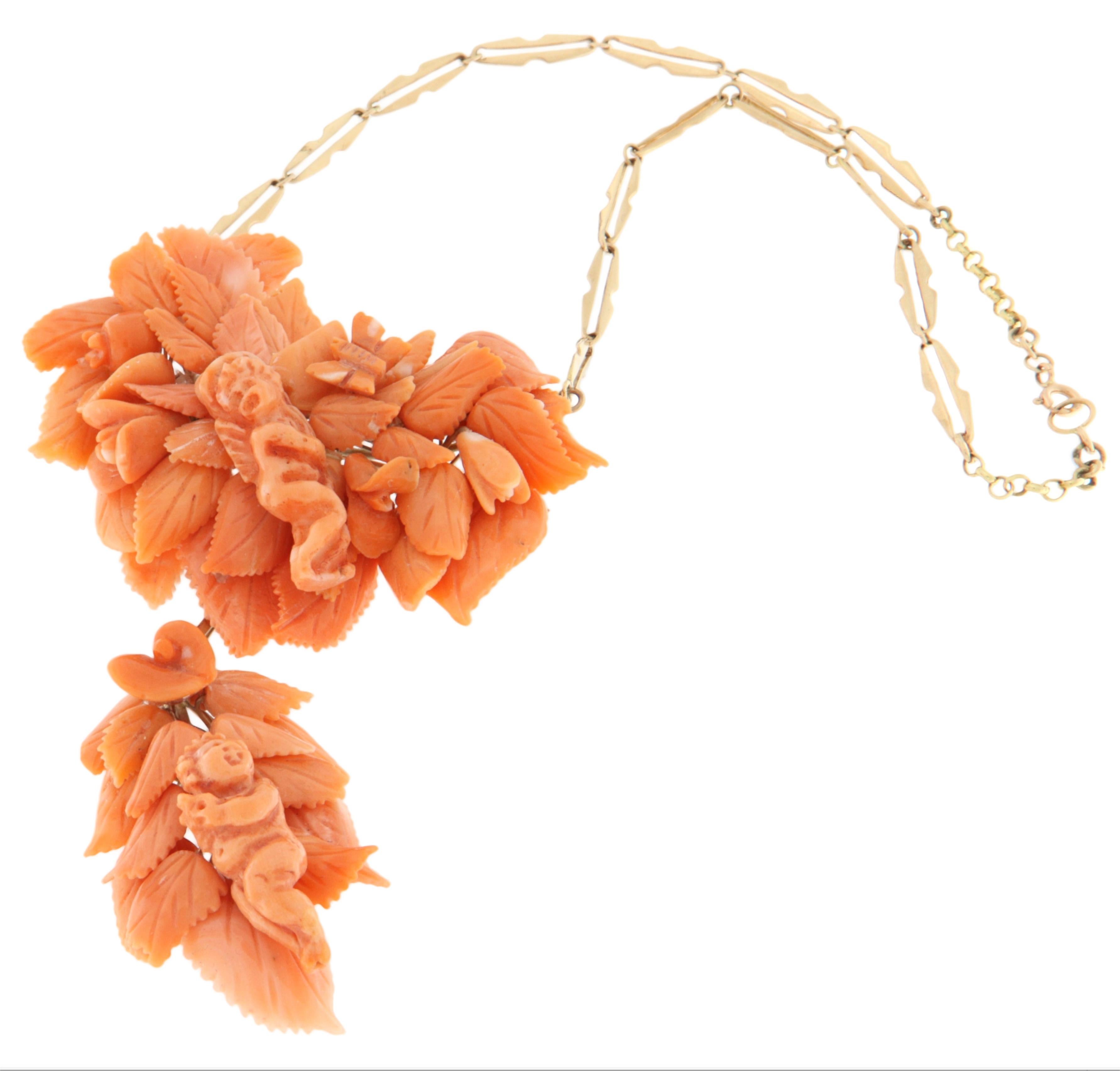 This exquisite antique necklace is a true vintage treasure, crafted in 9 karat yellow gold and adorned with intricately hand-carved natural coral. The central piece showcases a rich floral composition with detailed motifs of leaves and flowers,
