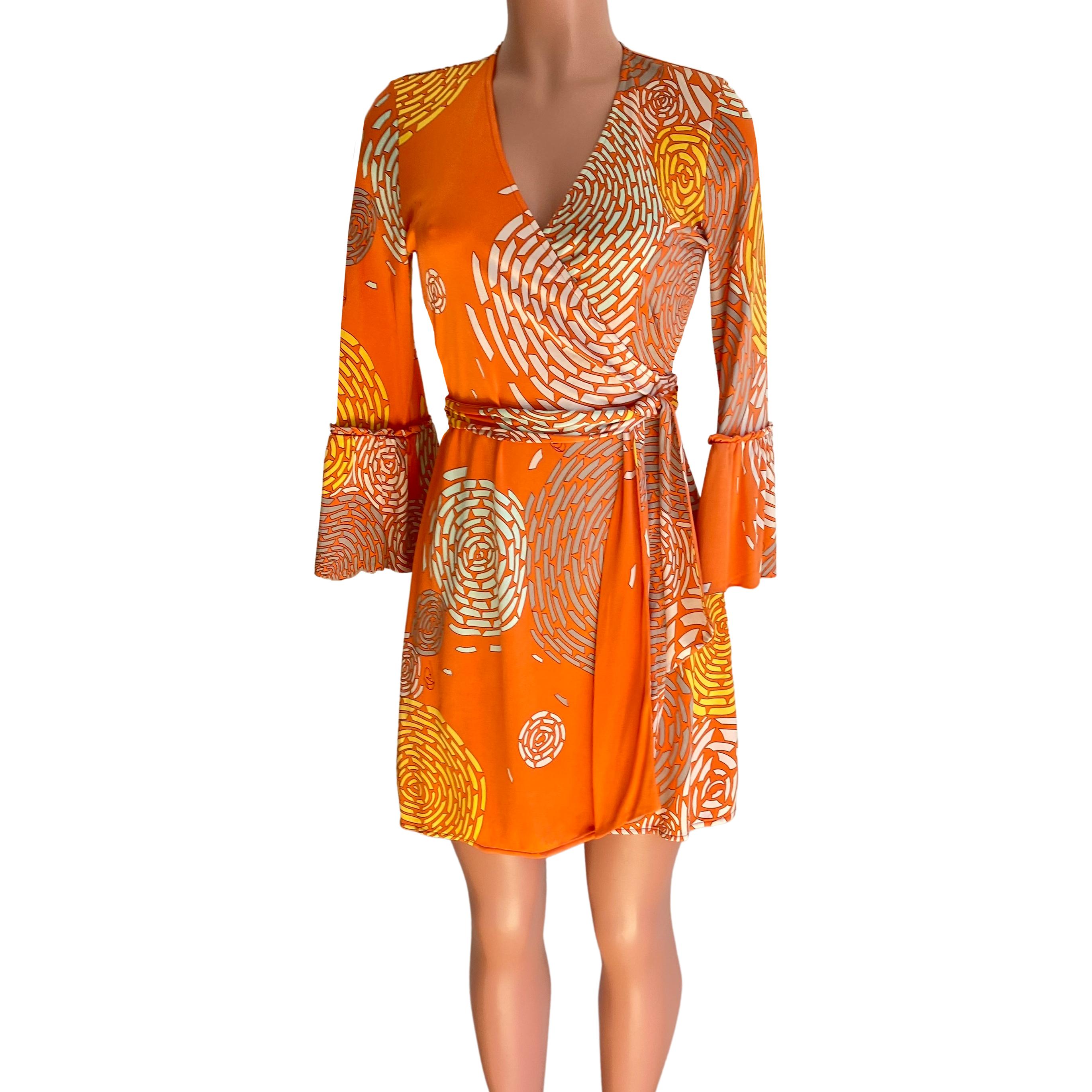 True wrap mini dress in flattering salmon coral orange print and statement sleeves.
In Flora's original abstract chrysanthemum print on rich coral orange background.
Flattering bell sleeves with braided details.
True wrap. Ties are long enough to be
