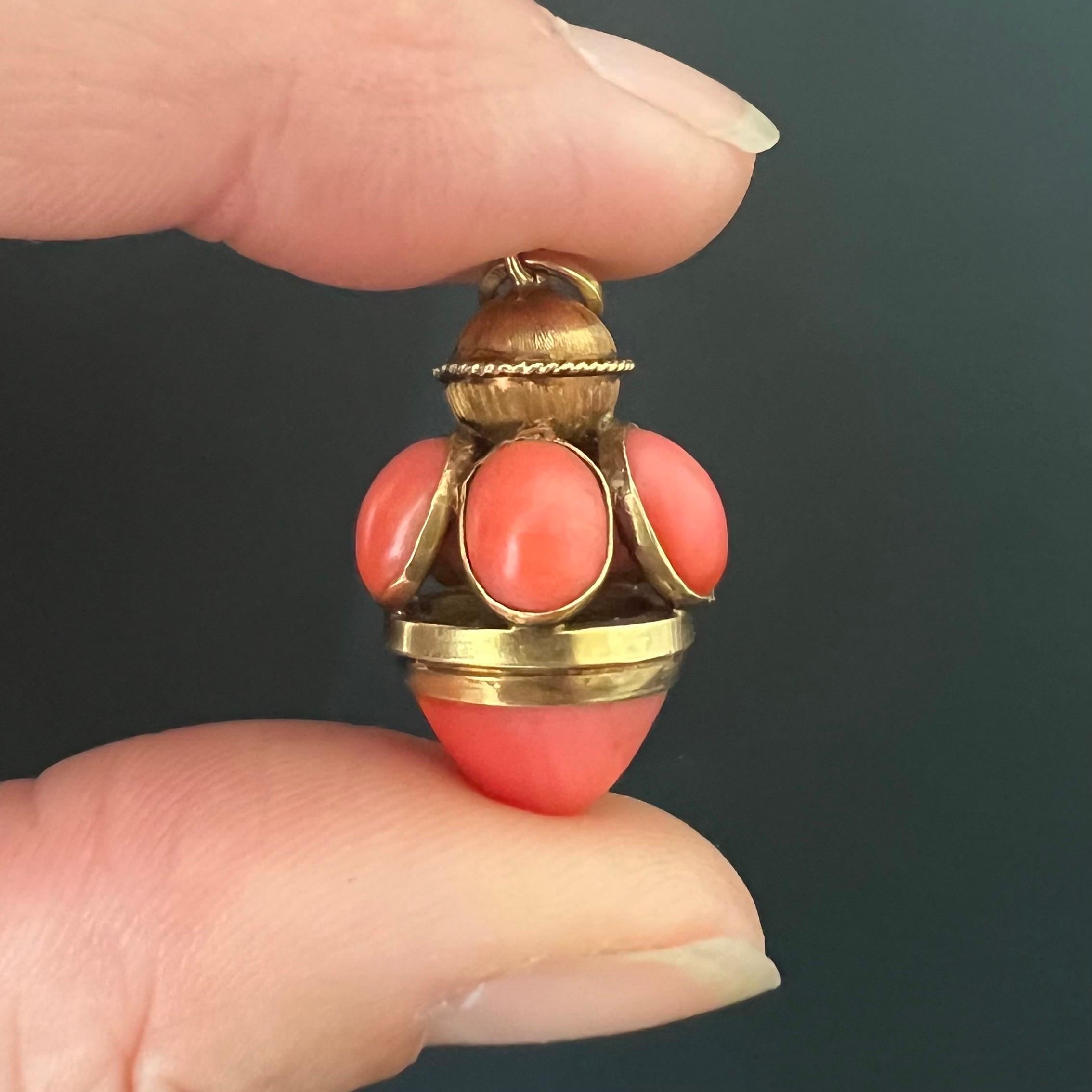 Este colgante de collar es una exquisita pieza de estilo farol que presenta una asombrosa disposición de piedras de cabujón de coral. El cuerpo del colgante está adornado con varios cabujones ovales de coral, cada uno engastado en bisel para
