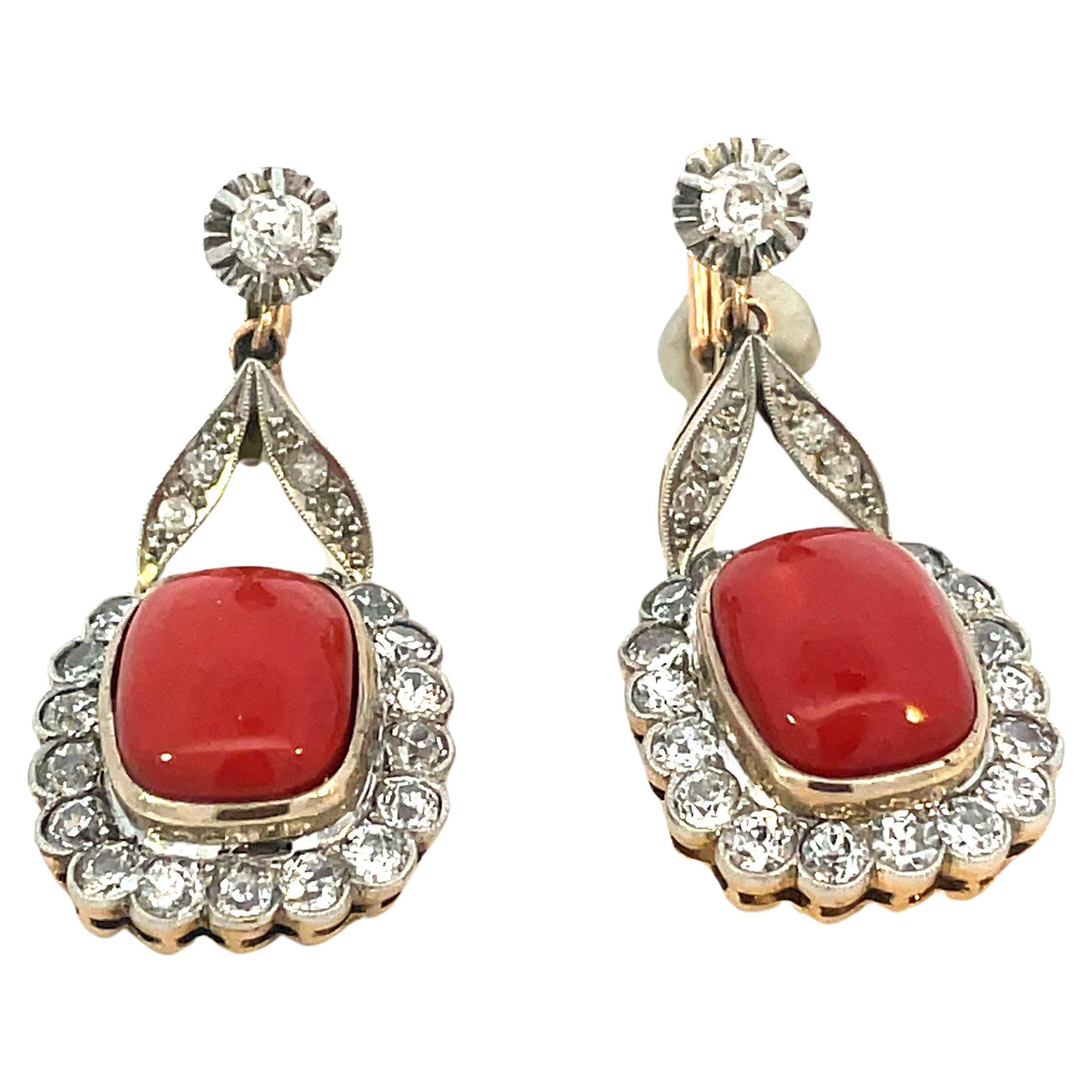 Pretty pair of Edwardian Earrings with 2 orange natural coral encrusted by 3 cts of round brilliant diamonds mounted in platinum and 18kt gold.

