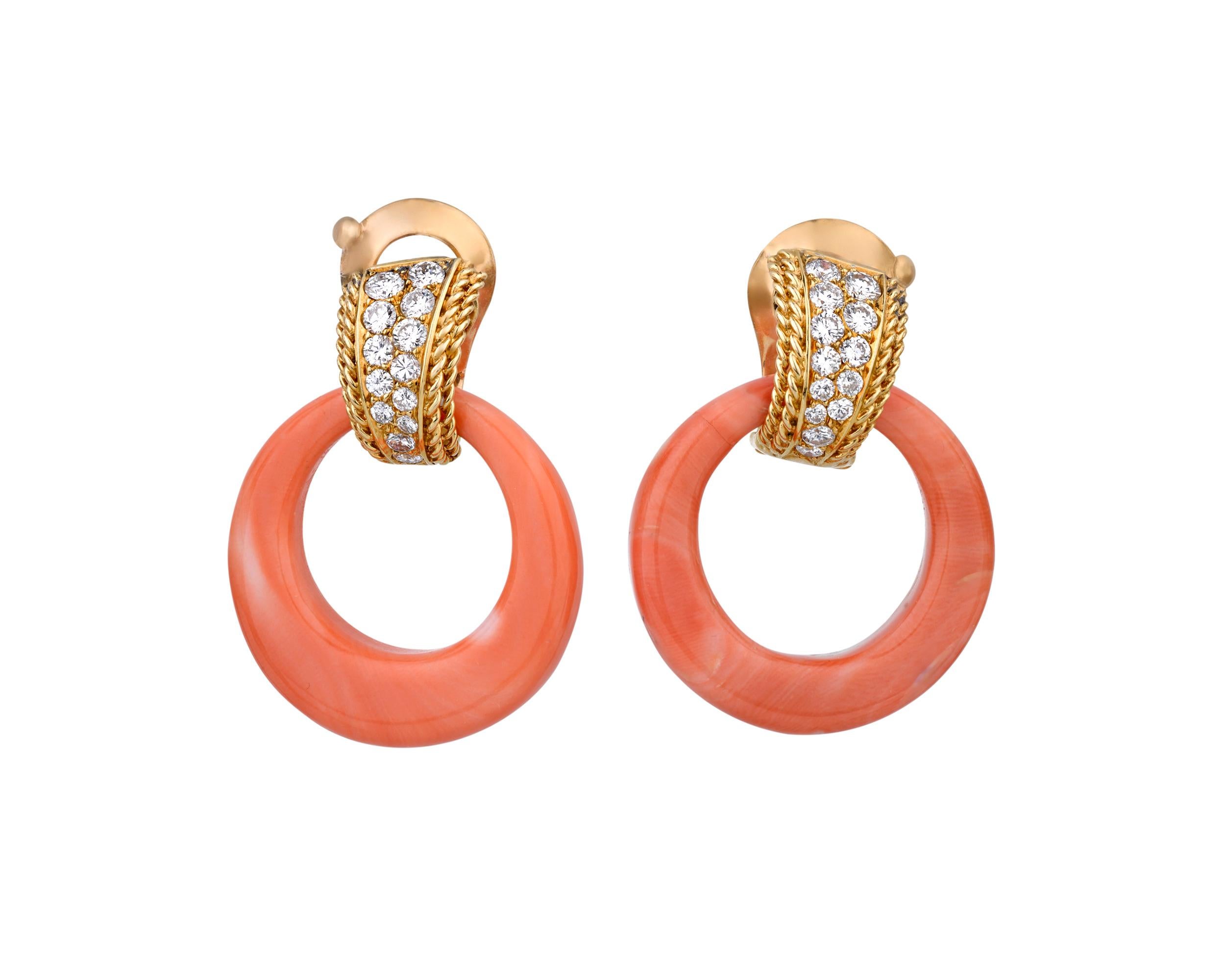 Striking coral forms these stunning hoop earrings by renowned French firm Van Cleef & Arpels. The expertly cut coral hoops are connected by a cluster of round diamonds set in 18K yellow gold. Since the firm's inception in 1896, Van Cleef & Arpels