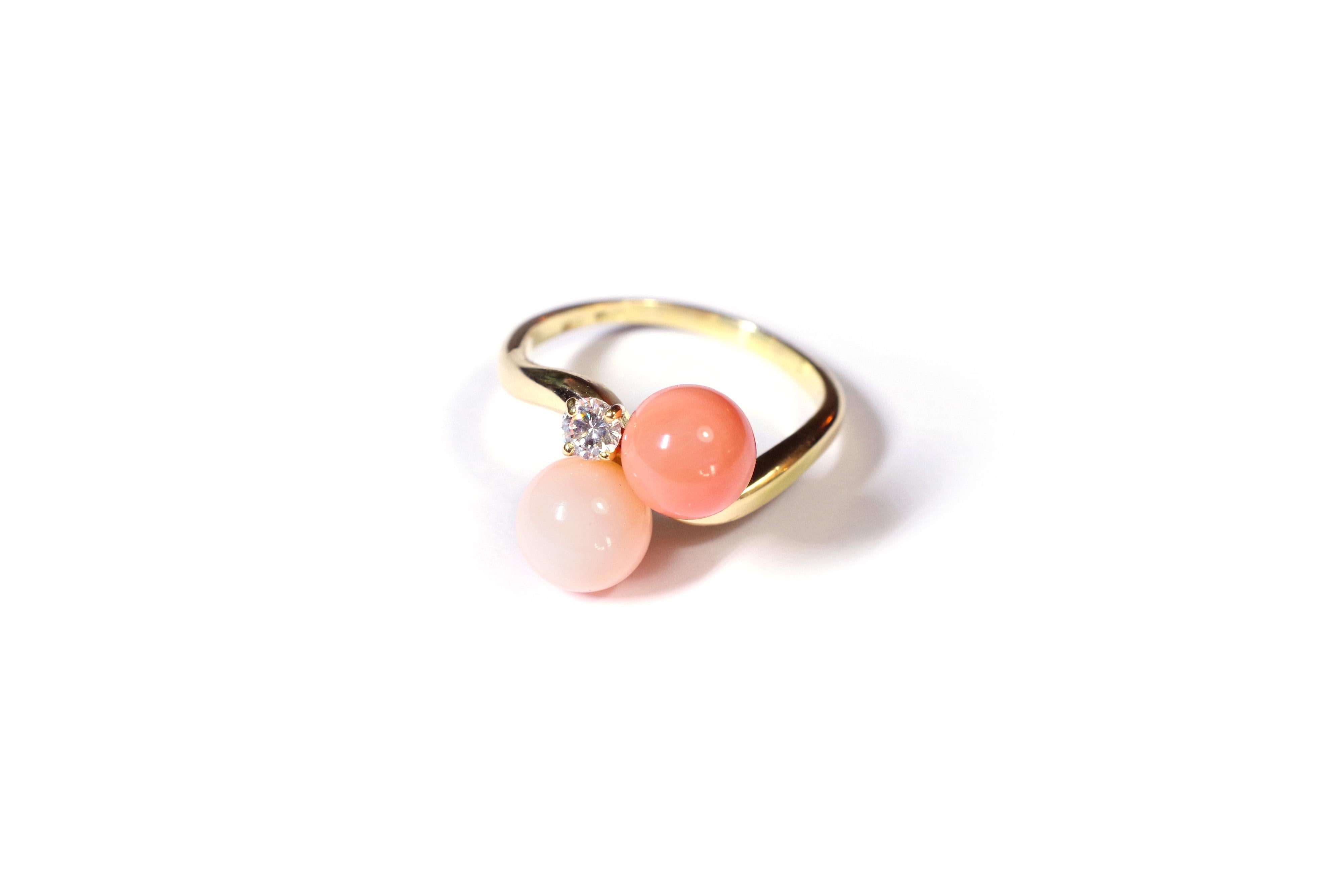 Coral and diamond ring in yellow gold 18 karats. Ring decorated with two coral pearls and a brilliant cut diamond. The first coral pearl has a lovely pale pink color, also called 