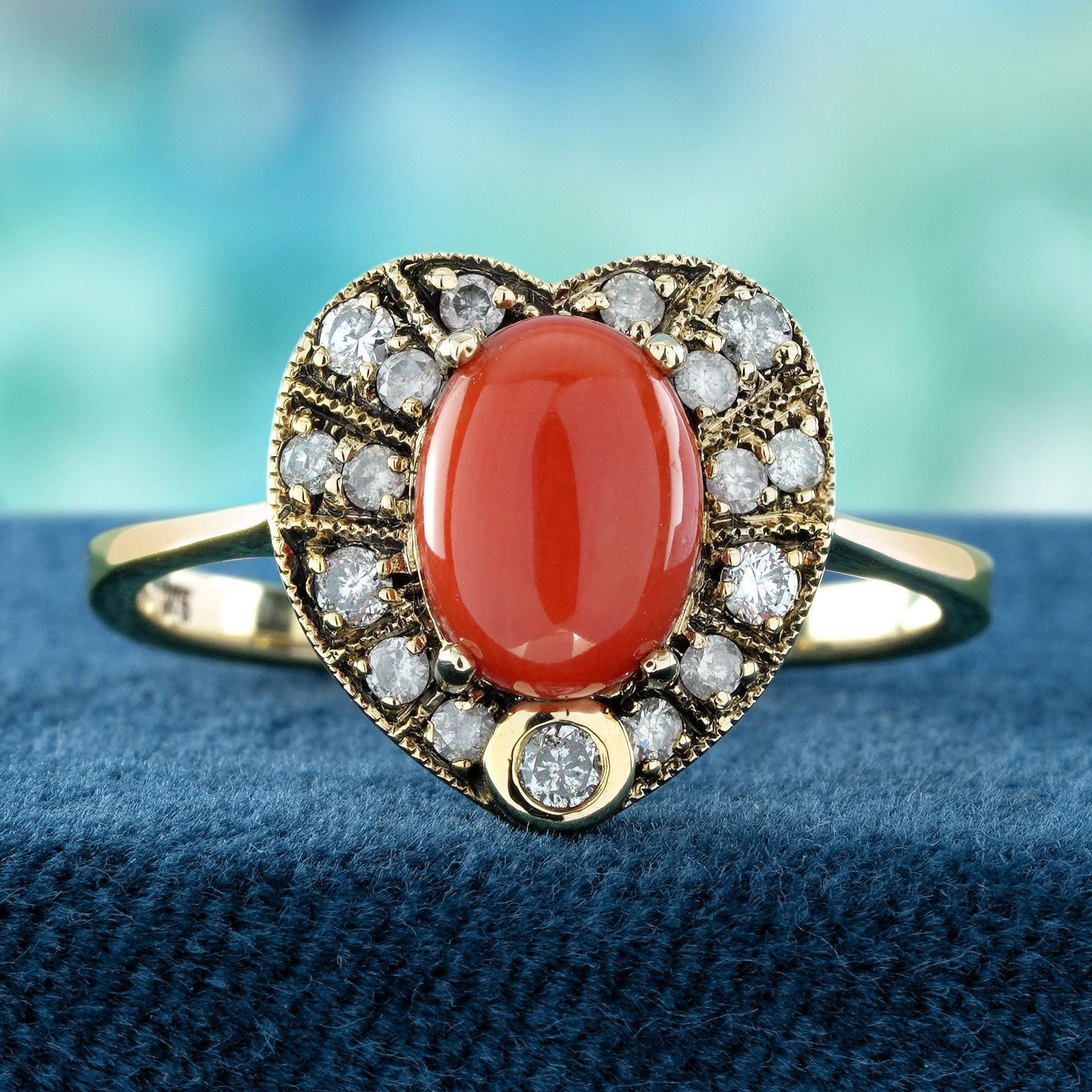 Dieser atemberaubende Ring mit einer ovalen Naturkoralle in der Mitte des Herzens ist von zarten Perlen umgeben, die sein weiches, feminines Design unterstreichen. Die verschlungene Herzform im Vintage-Stil ist mit funkelnden Diamanten verziert, die