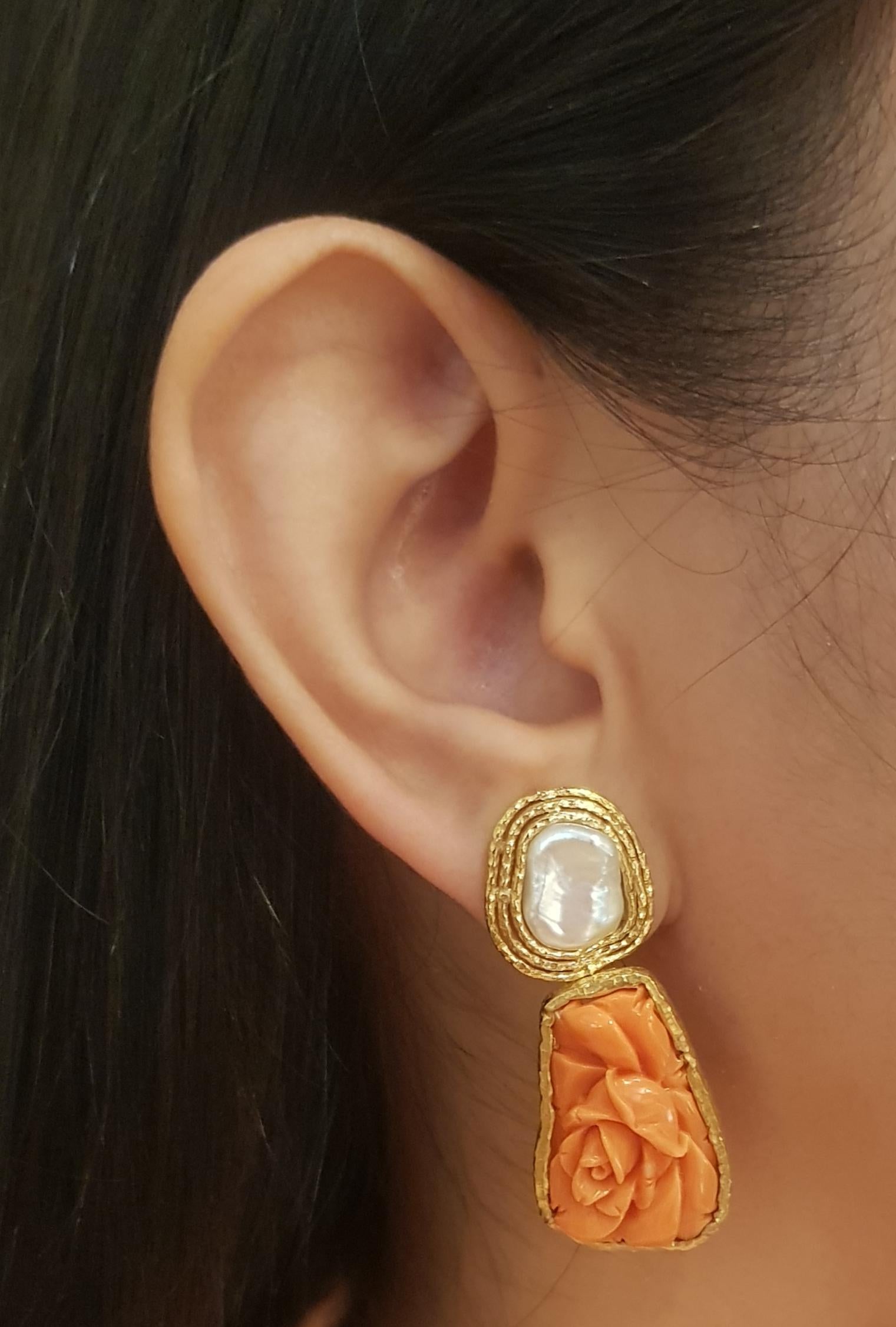 Orecchini di corallo e perle d'acqua dolce con montatura in oro 18K

Larghezza: 1.7 cm 
Lunghezza: 4.4 cm
Peso totale: 18,72 grammi

