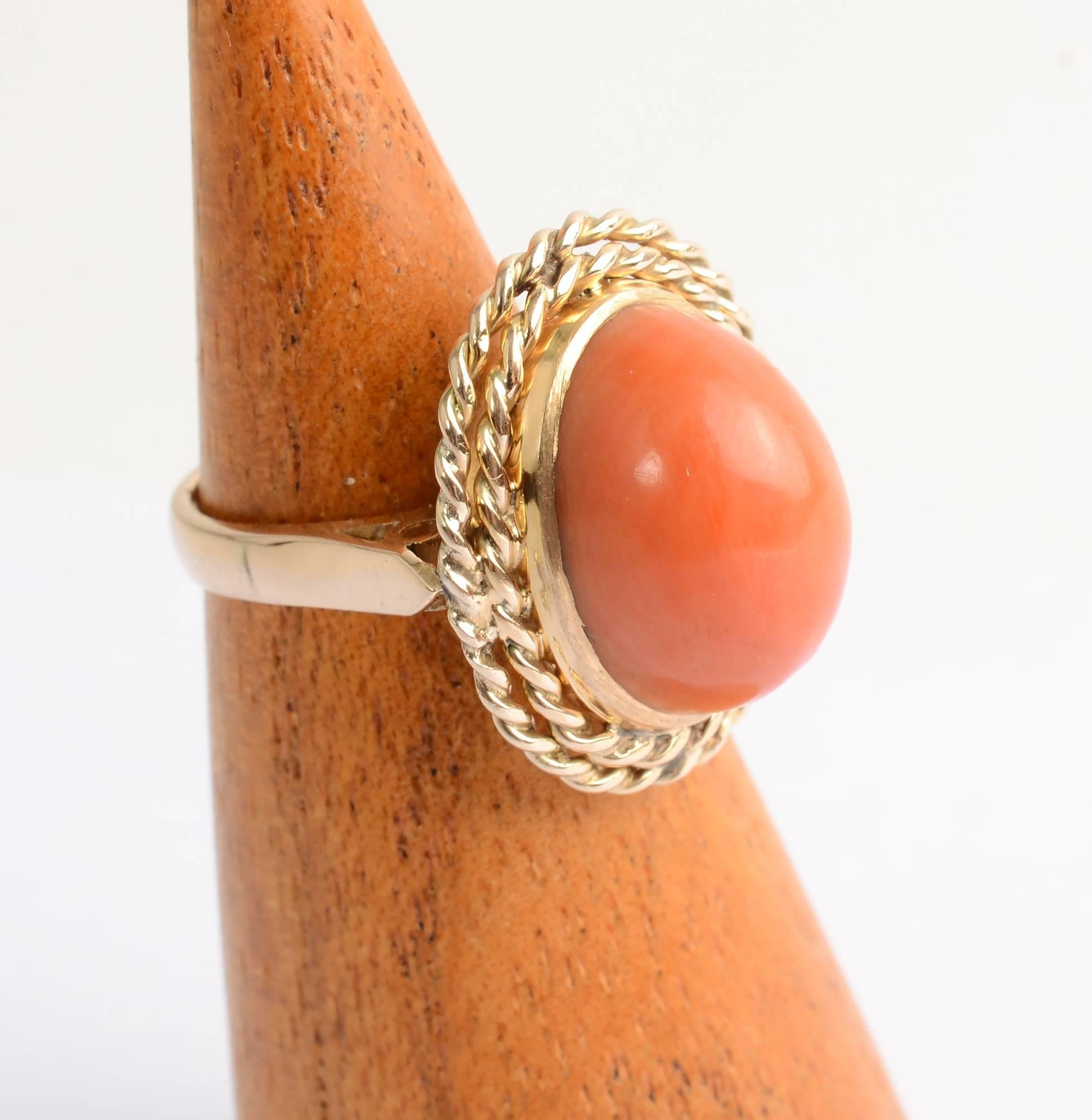 Classic design coral ring with two outside rows of twisted gold. The oval stone measures 9/16