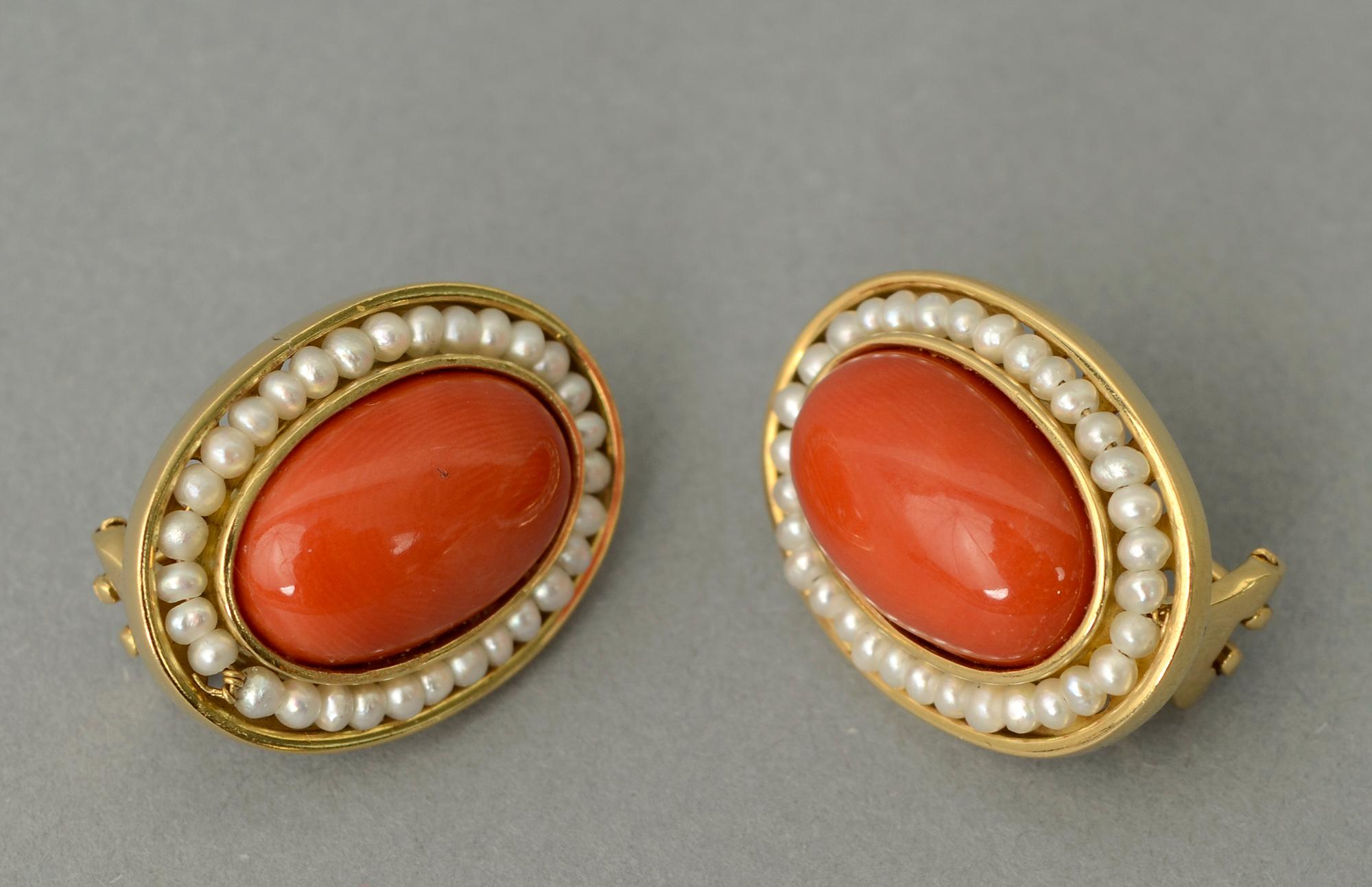 Unusual coral and natural pearl earrings set in 18 karat gold. The oval coral stones are half an inch by three quarters of an inch. Pearls are natural. The backs are clips and posts. A matching ring is available listed as item LU1336667831.