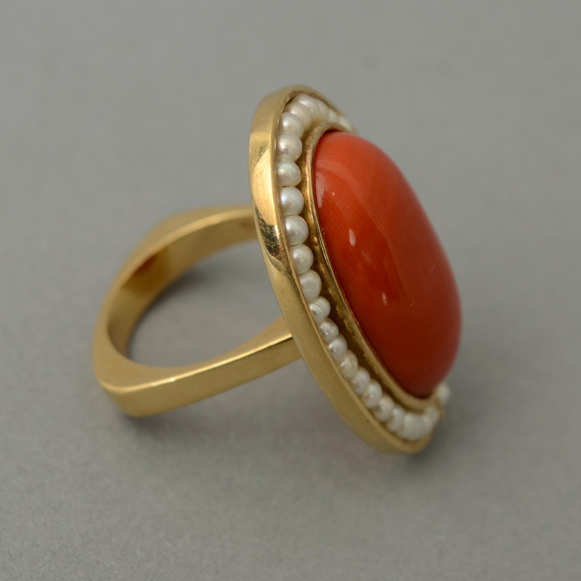 Striking oval ring of coral and natural pearls. The oval coral stone measures 7/8 