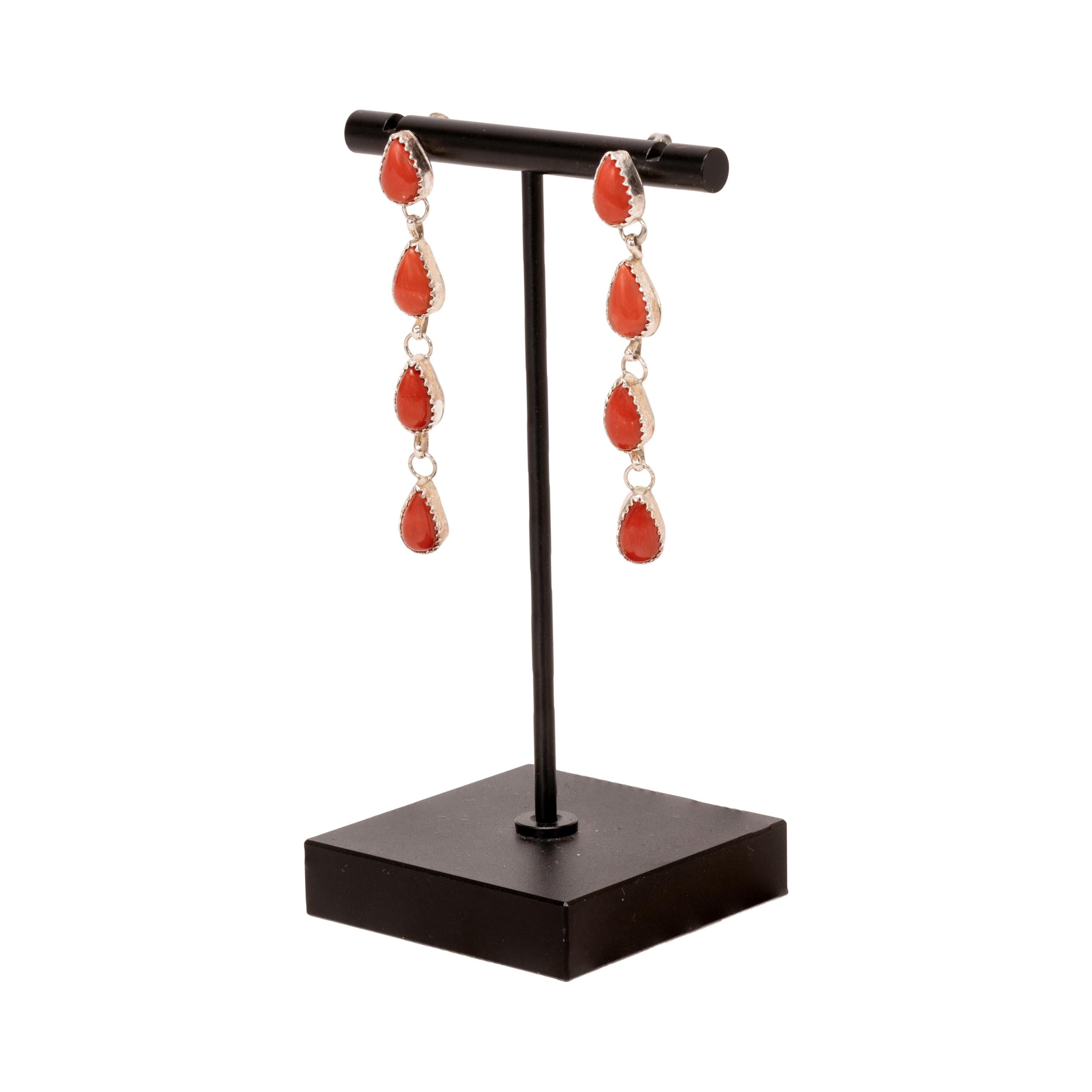 Red branch coral and sterling silver earrings. Each earrings having 4 teardrop shaped stones in sterling silver setting. Arranged in a dangle design on stud posts. Unmarked. 20th century. Size: 2 1/4