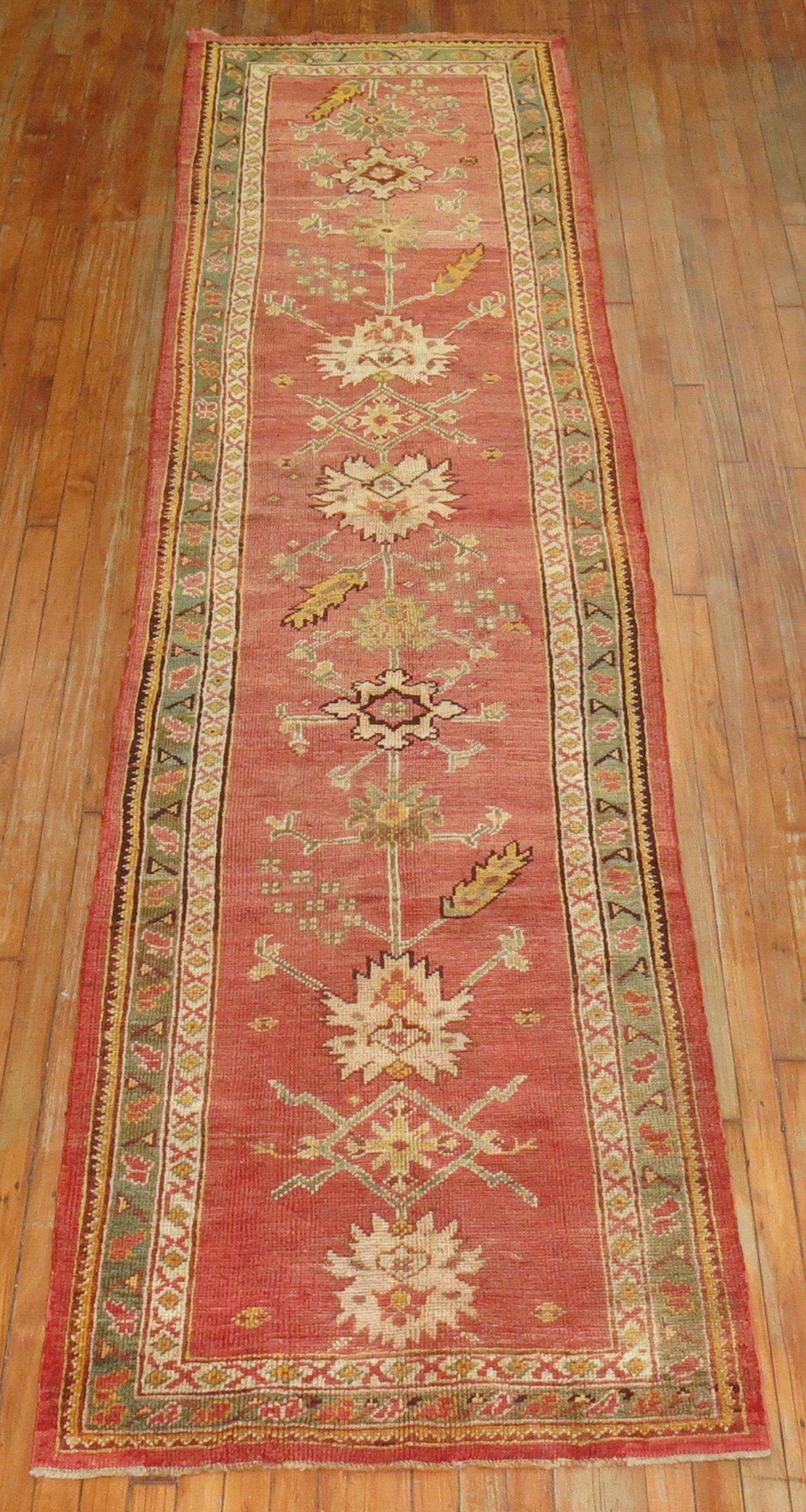 An authentic early 20th century predominantly coral antique Turkish Oushak runner.