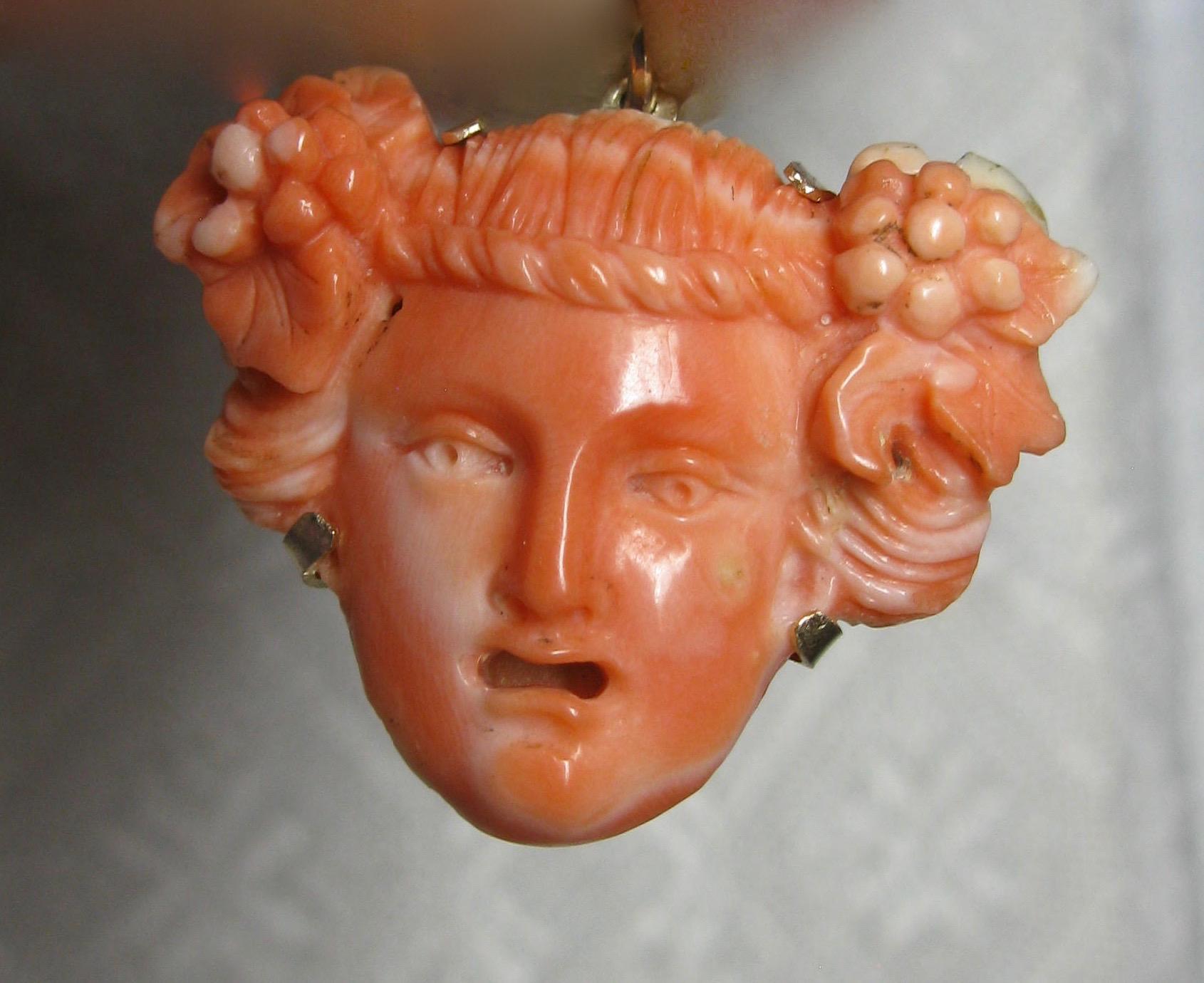 A stunning antique Victorian - Art Deco Pendant in gorgeous hand carved natural Coral of the face of Bacchus, also known as Dionysus.  The coral pendant is a masterpiece of artistic expression - the face is carved with exquisite detail throughout,