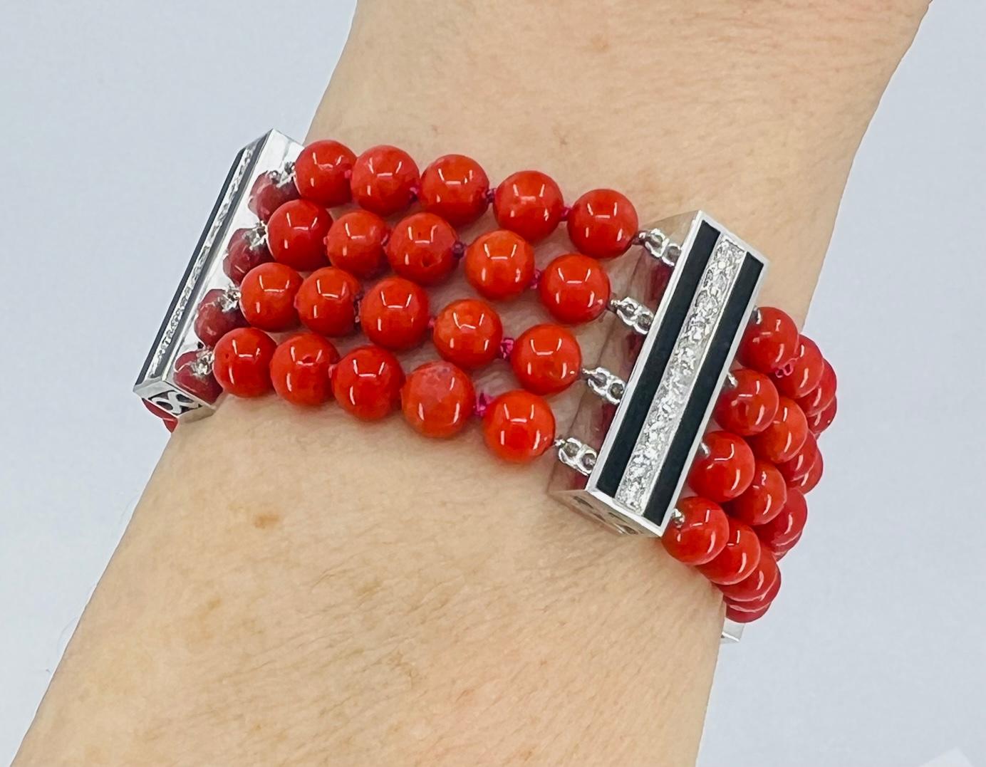 Gorgeous bracelet featuring four-strand Mediterranean coral beads alternating with four white gold bars set with diamonds and accented with black enamel. 
The bracelet is 7