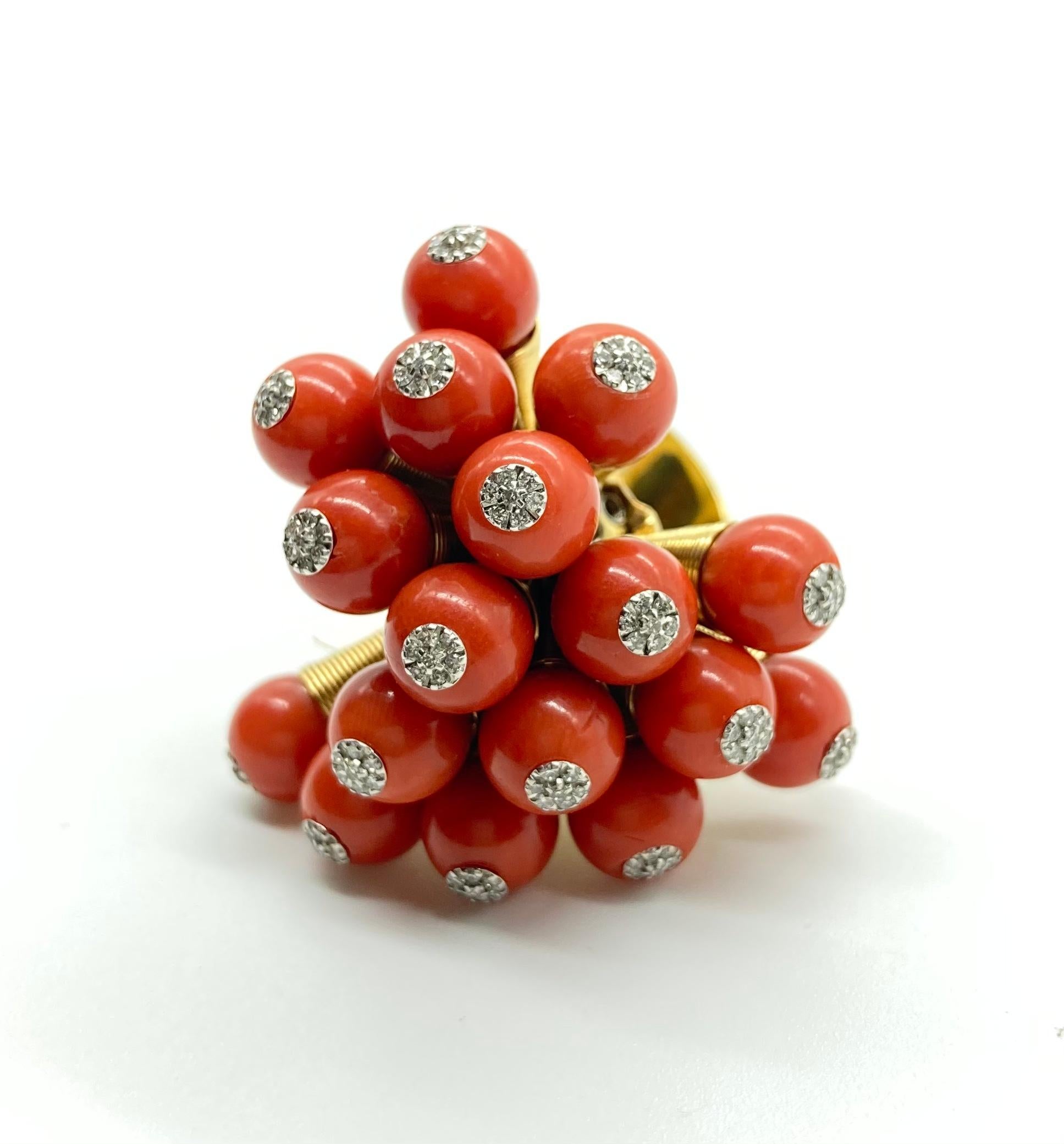 A fun vintage kinetic ring in 18 karat yellow gold with spring-mounted coral beads and diamonds. Circa 1970.