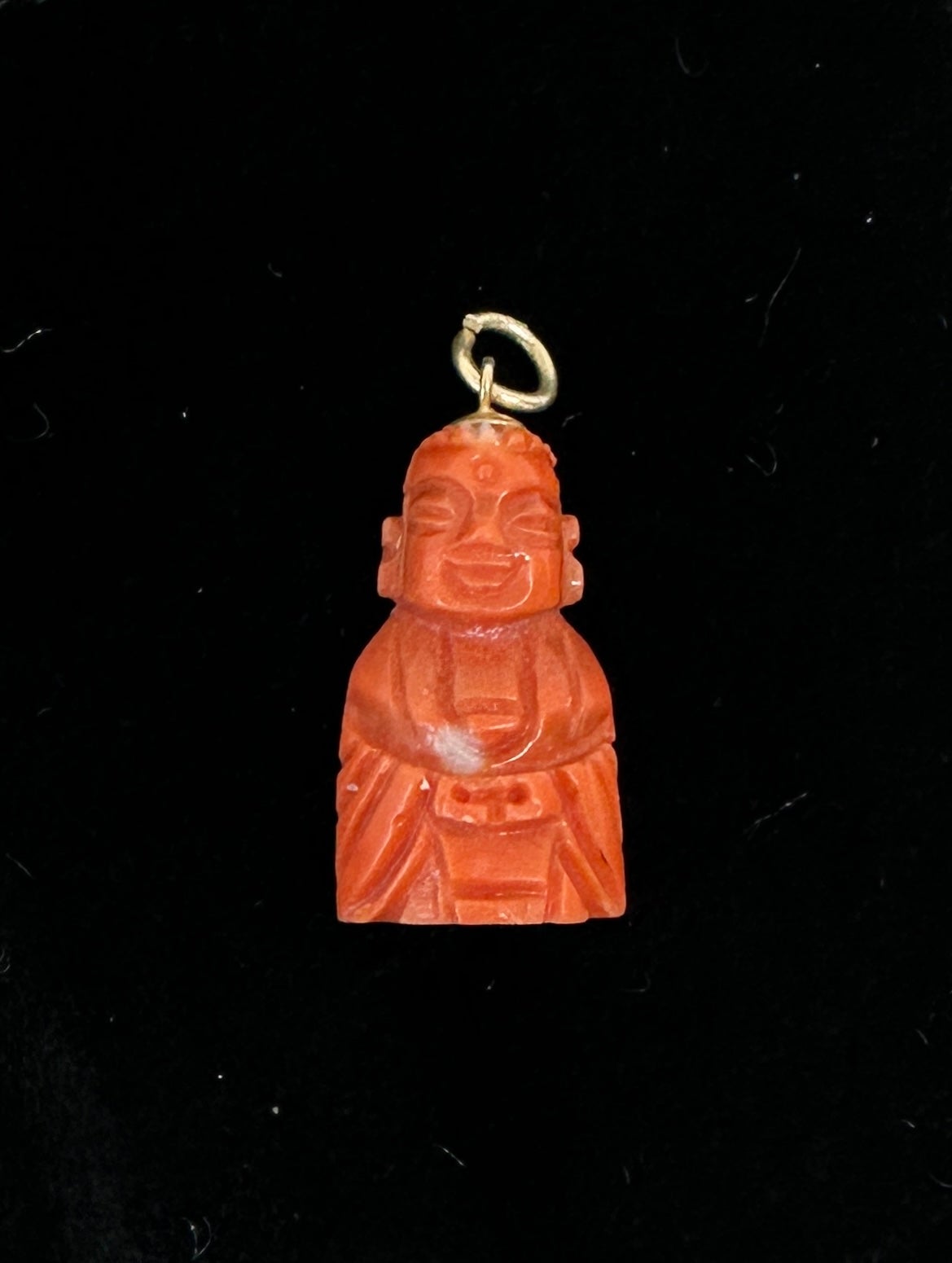 This is a wonderful antique Art Deco Coral Buddha Pendant or Charm in 14 Karat Yellow Gold.  The Buddha is exquisitely carved in natural Momo Coral.  The Buddha miniature is a beautiful creation with wonderful details in the face, hair and robes in