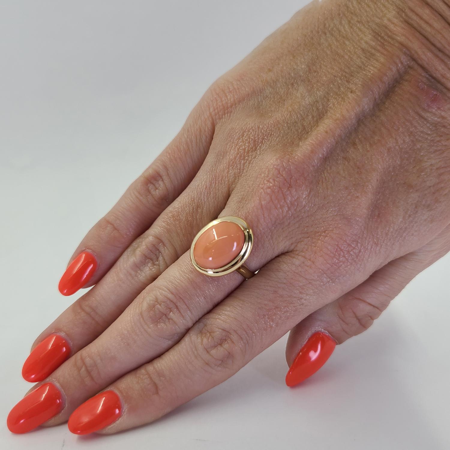 14 Karat Yellow Gold Ring Featuring A Bezel Set 14mm x 10mm Oval Cabochon Cut Coral. Finger Size 6.5. Purchase Includes One Sizing Service Upon Request, Prior to Shipping. Finished Weight Is 3.9 Grams.