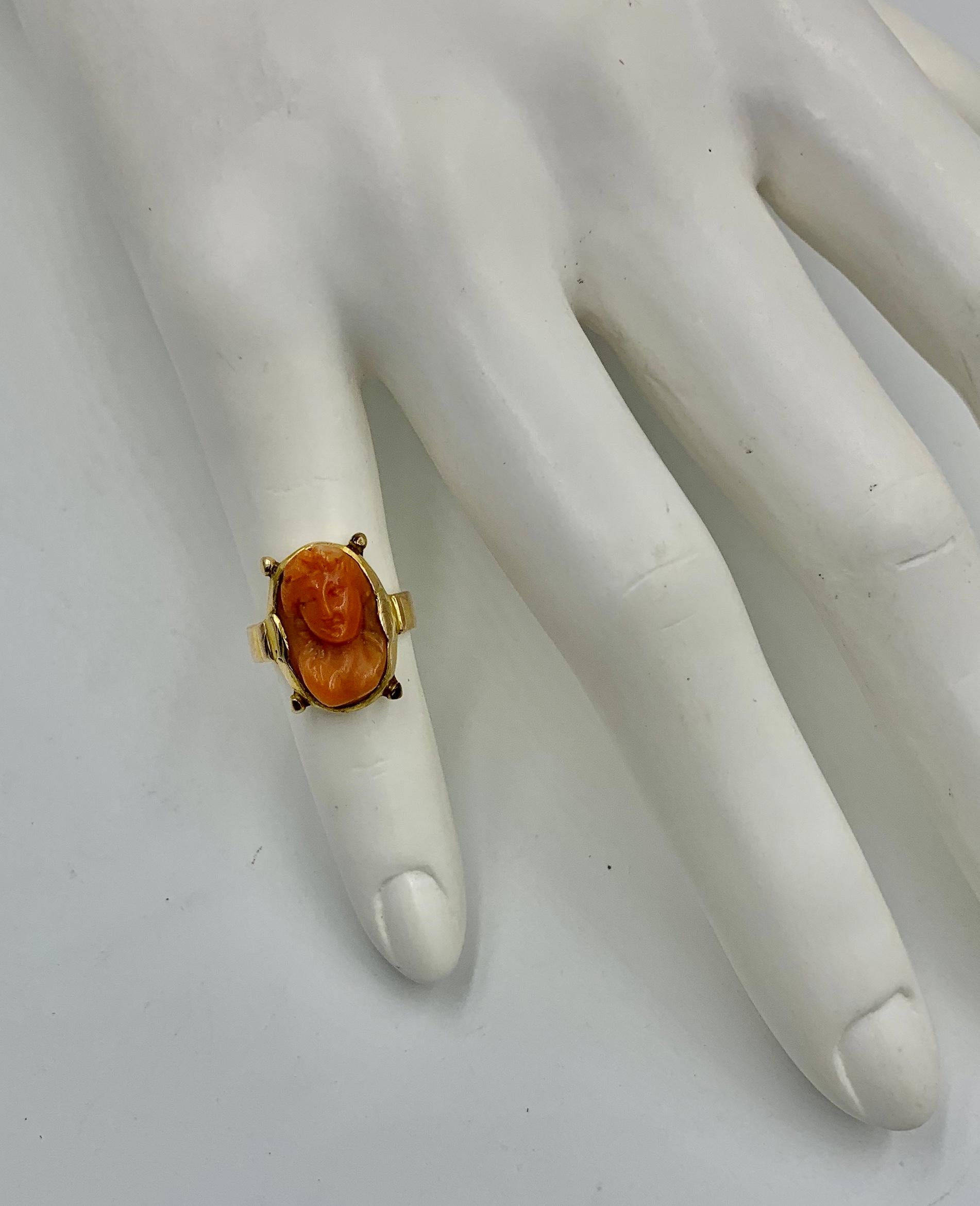 A superb Victorian - Belle Epoque deeply carved Coral Cameo Ring depicting a nude woman with absolutely magnificent detail and artisanship in a beautiful and elegant Etruscan Revival setting in 14 Karat Gold.  The ring dates to circa 1850-1880.  The
