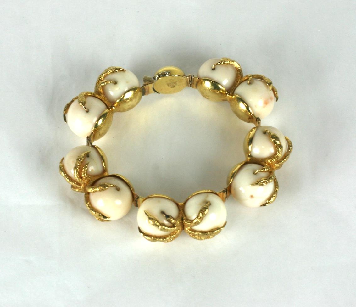 Bracciale con artiglio di corallo degli anni '70 in oro 18 carati. Il bracciale è realistico, con coppie di chele che reggono perle di corallo in ognuna delle 5 maglie del bracciale. 
Un design originale e sorprendente con un'atmosfera moderna e