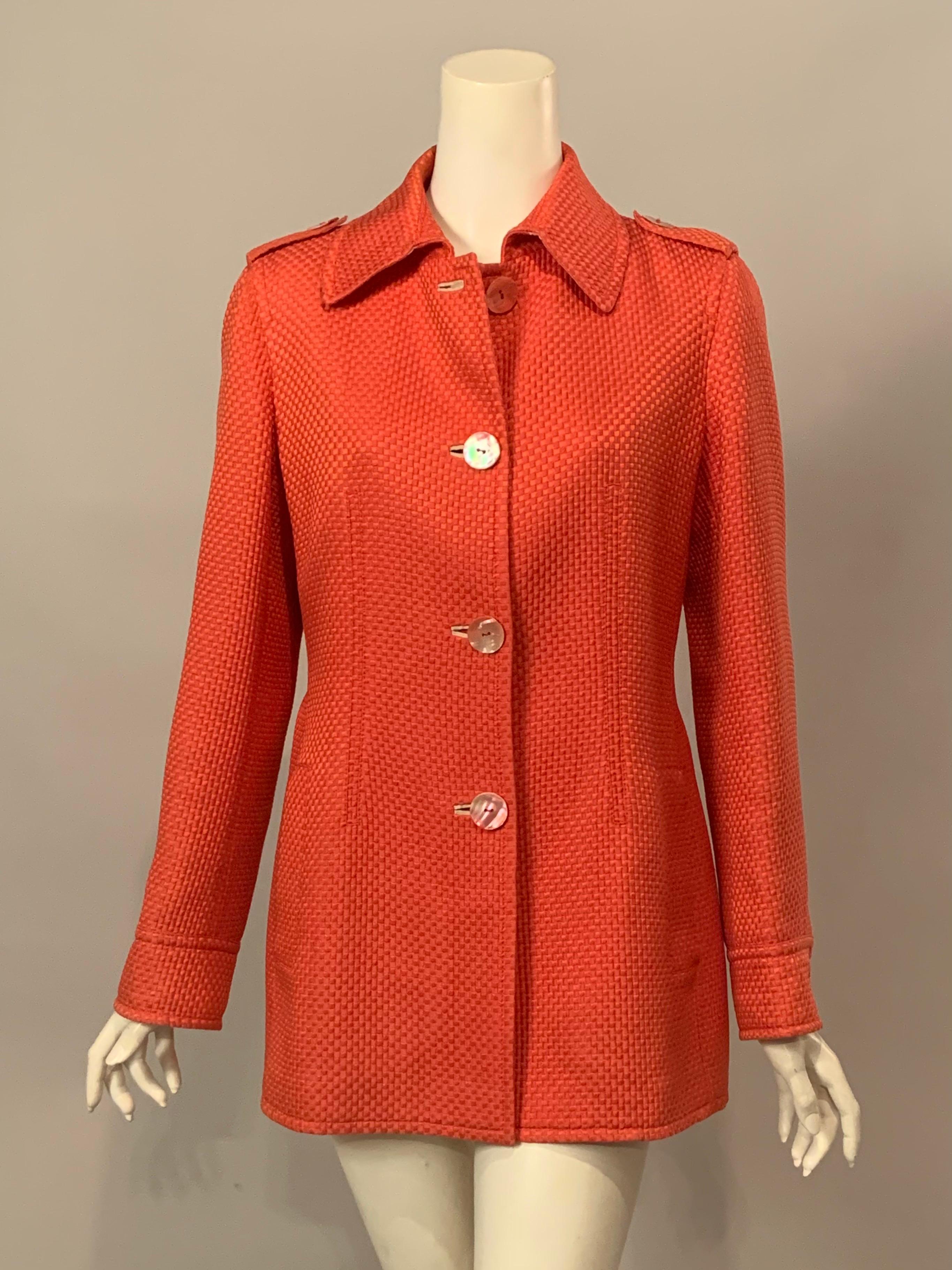 The Italian luxury brand Brioni used a beautiful shade of coral cotton and  silk blend for this light weight belted jacket, perfect for Spring. It has four pink Mother of Pearl buttons at the center front and one on each cuff.  There are two deep