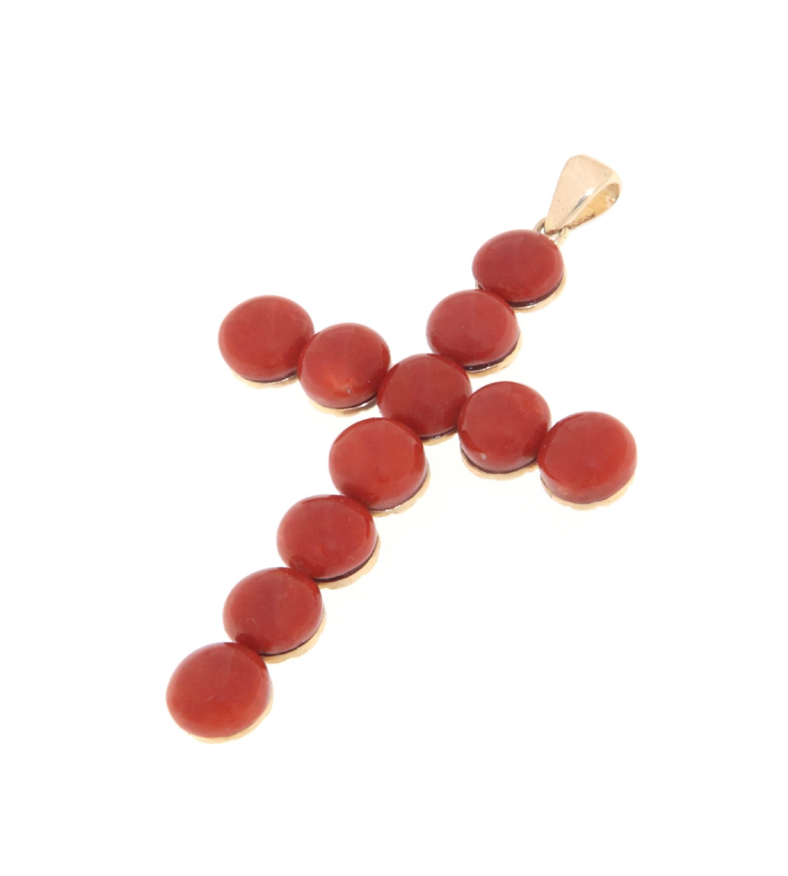 This elegant 9-carat yellow gold cross represents a sublime fusion of tradition and craftsmanship. A distinctive piece in the realm of religious jewelry, this cross is adorned with Sardinian coral buttons, known for their deep red color and highly
