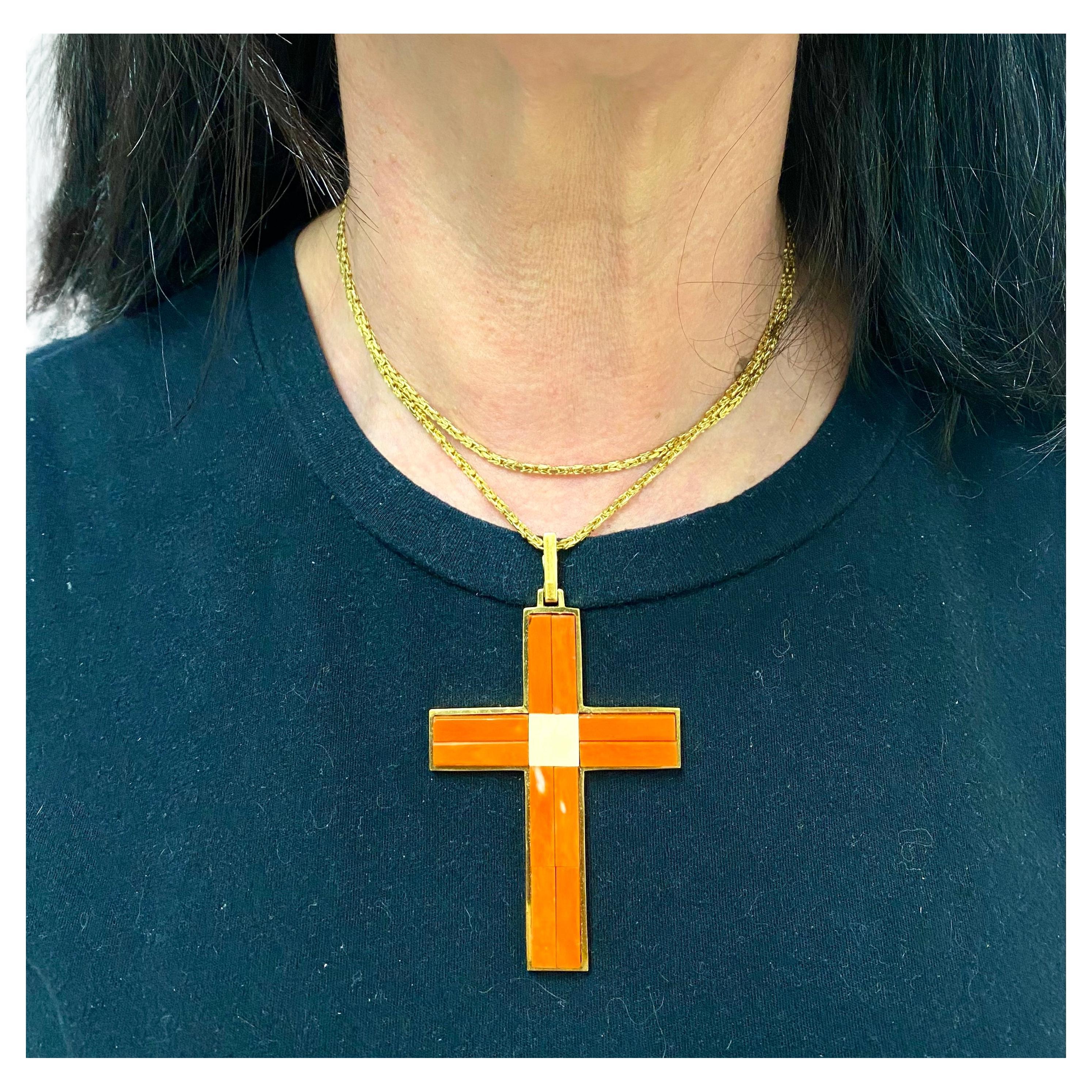 An impressive vintage coral cross pendant, made of 18k gold. The coral planks are staged in the gold base that is equipped with a large rectangular loop. The center is crafted of the contrasting white coral, which makes the cross look even brighter