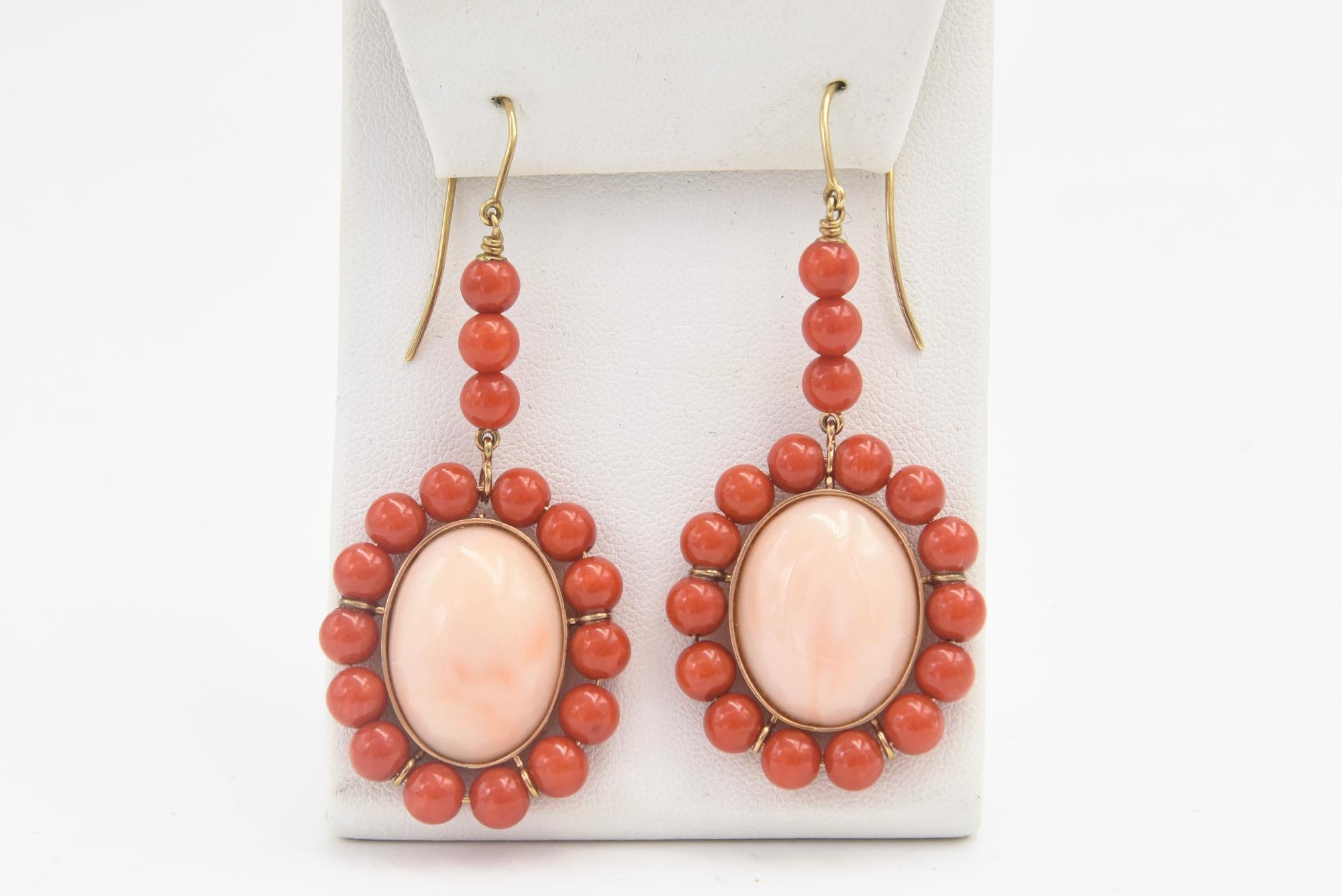 These earrings feature a large oval cabochon angel skin coral piece measuring approximately  .80