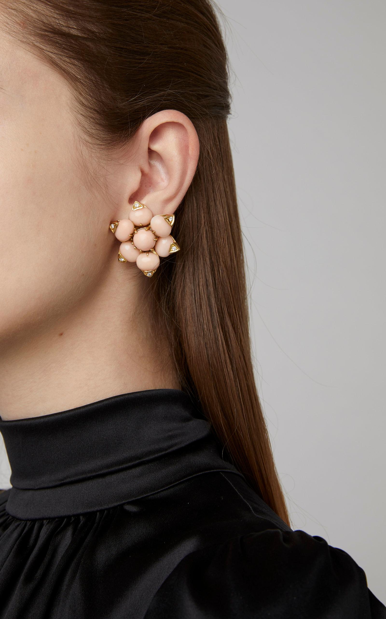 A chic pair of pink coral ear-clips, mounted on 18kt yellow gold, highlighted by round cut diamonds. Made in Italy, circa 1960.